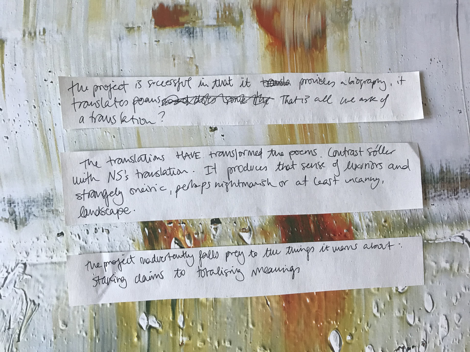 Three snippets of paper on a messy painted background