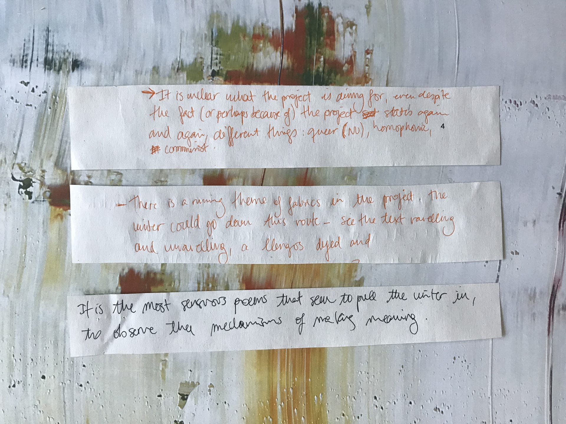 Three snippets of paper on a messy painted background