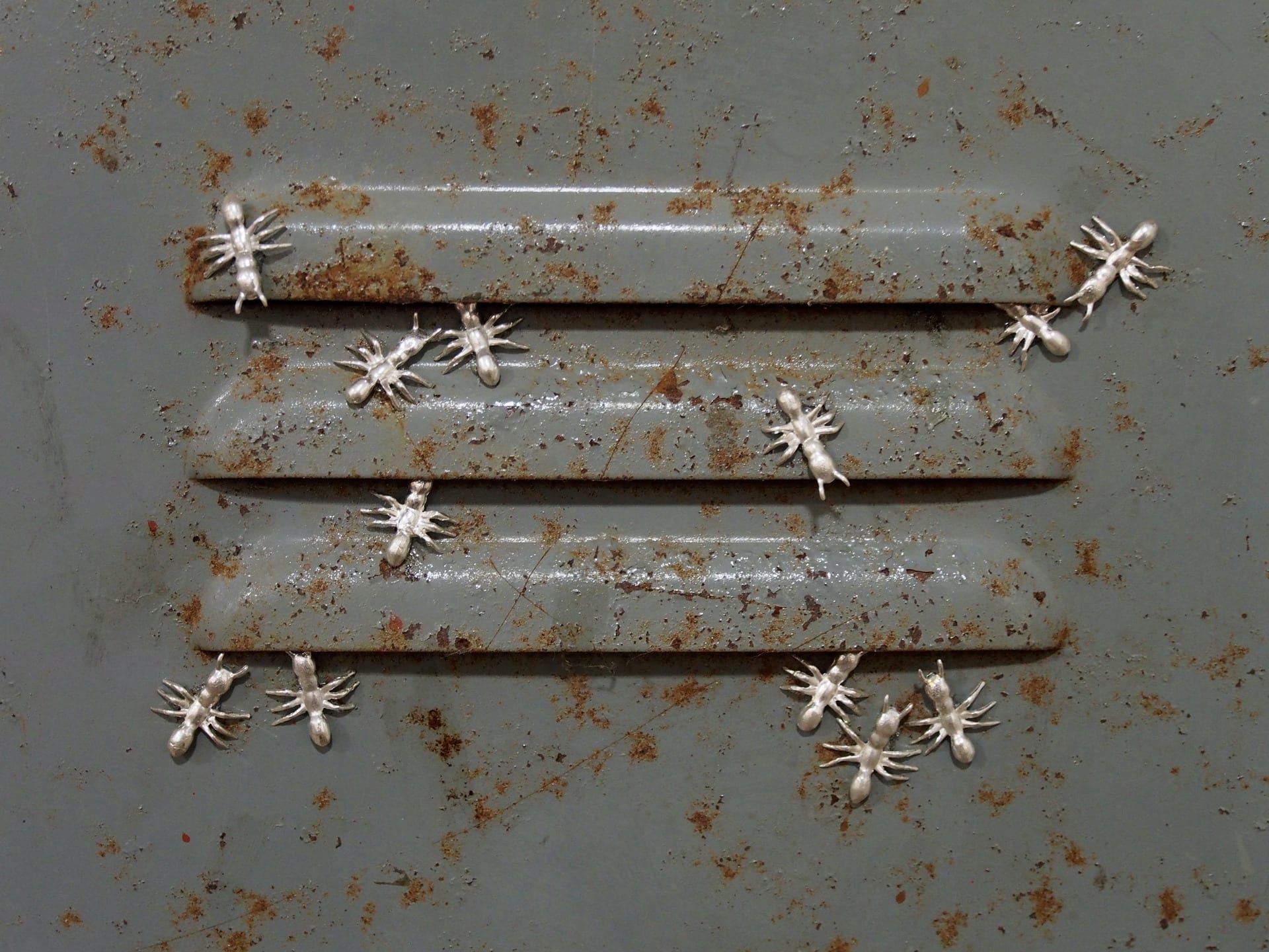 locker vent with silver ants swarming around it