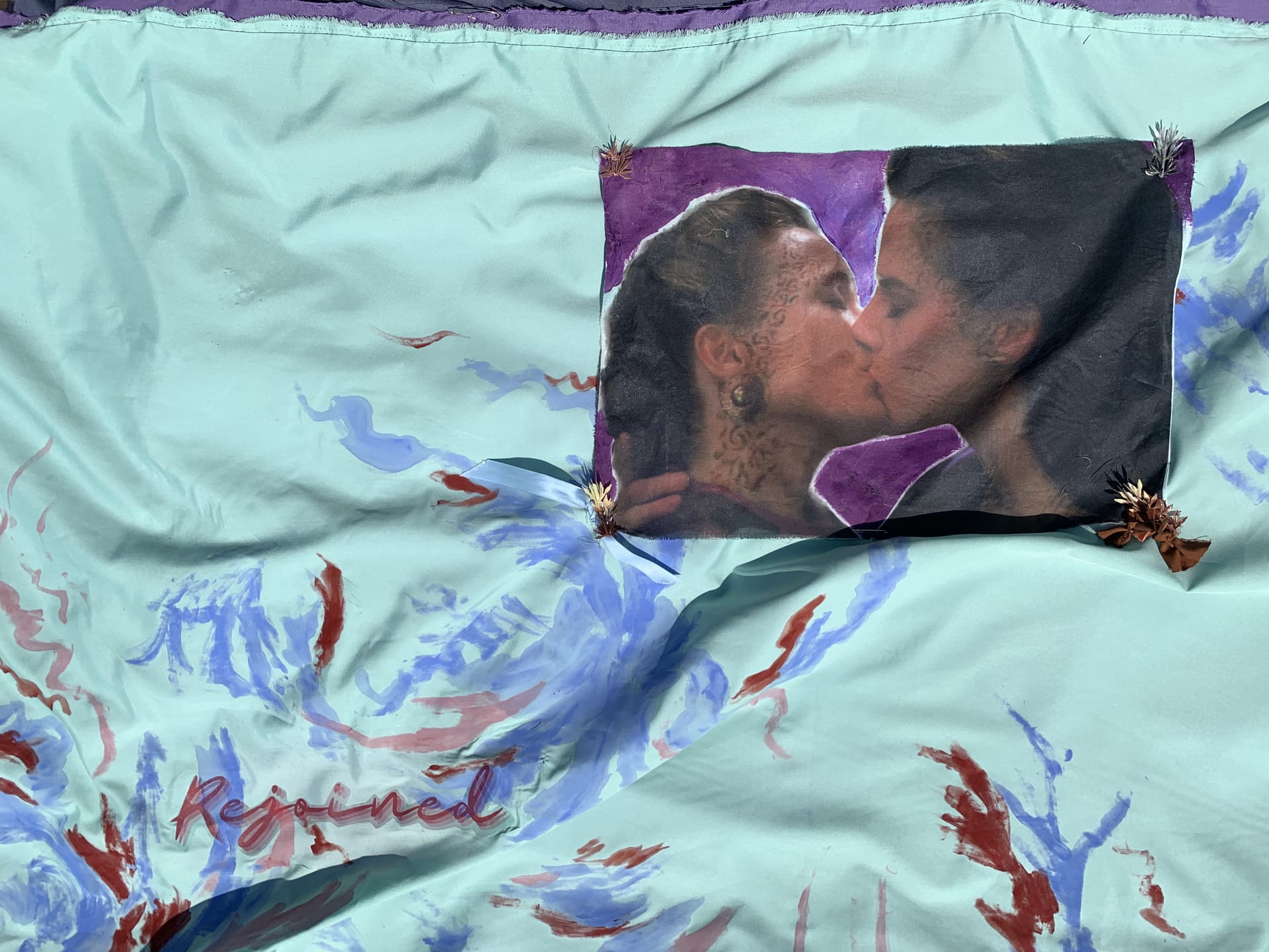 swirls of paint on fabric surrounding the image of a scene from star trek featuring two women kissing.