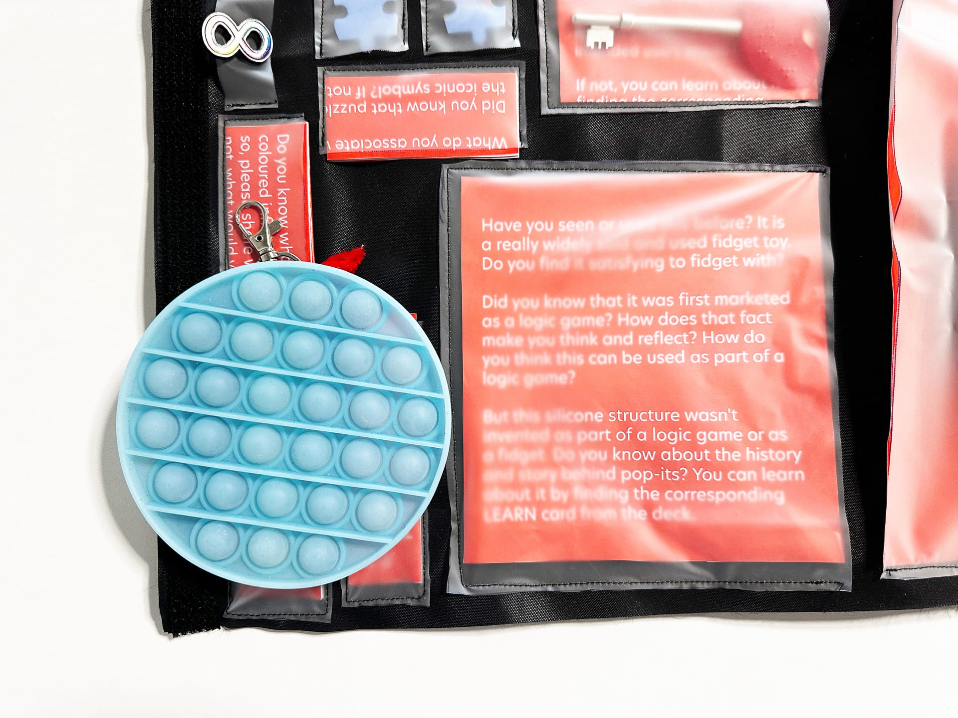 a pop-it fidget is placed next to its discussion prompt in the activity bag