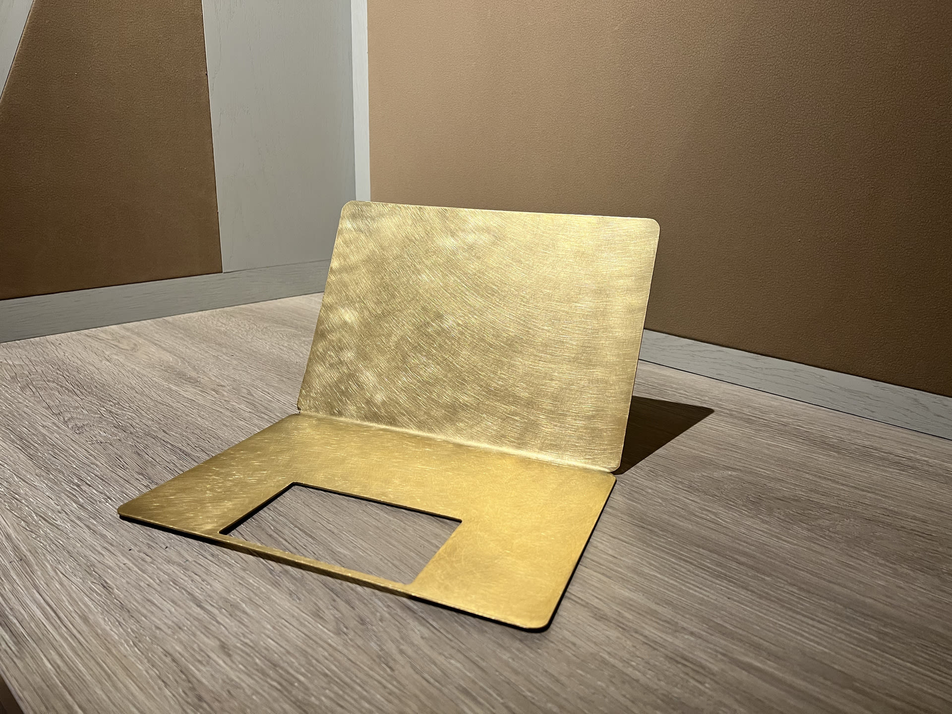 Laptop shaped object made of metal sheet - golden in colour, with a gap where the touch pad should be