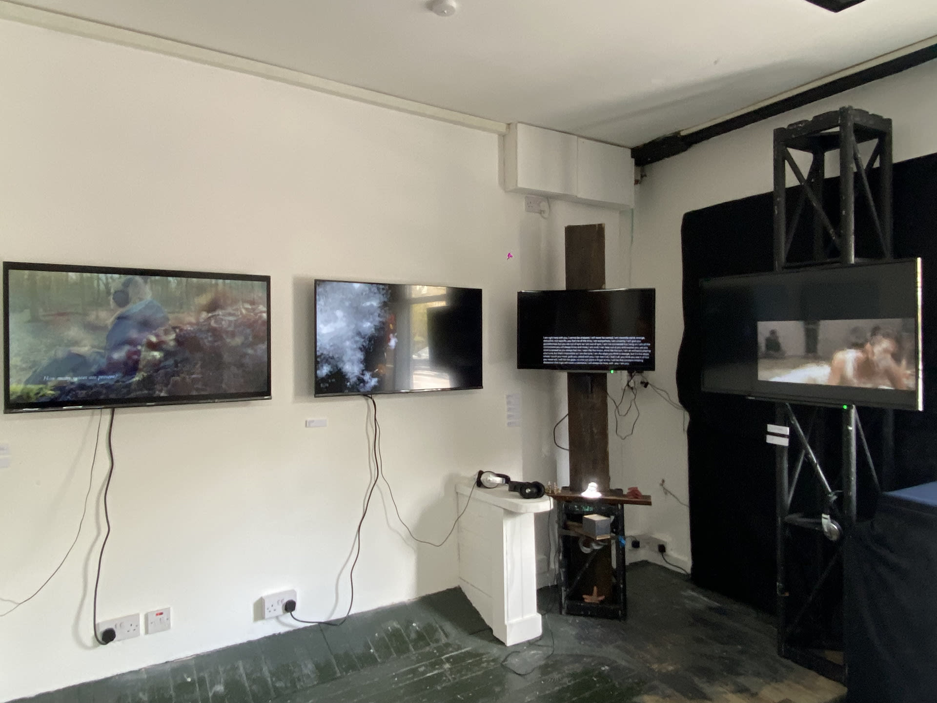 Four screens of various artists work on display. 