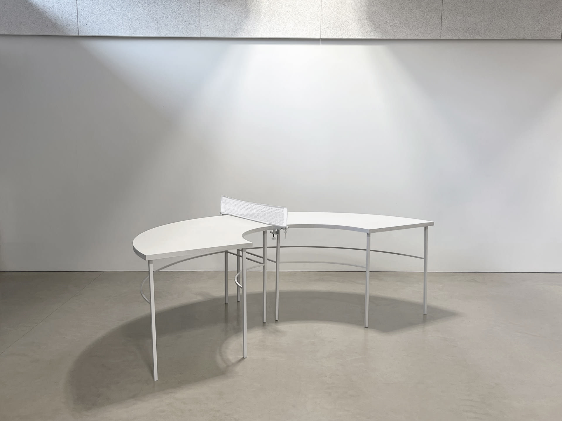 A ping pong table is built in semi circle and painted in white.