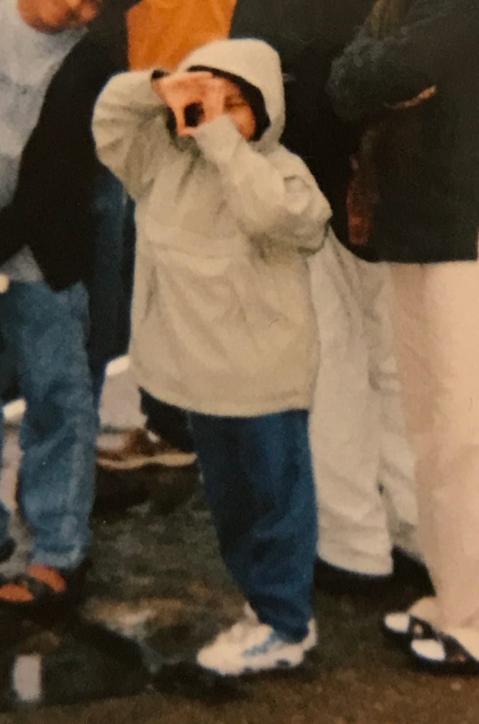 A photo of a young Kulsum makes a frame with her hands 