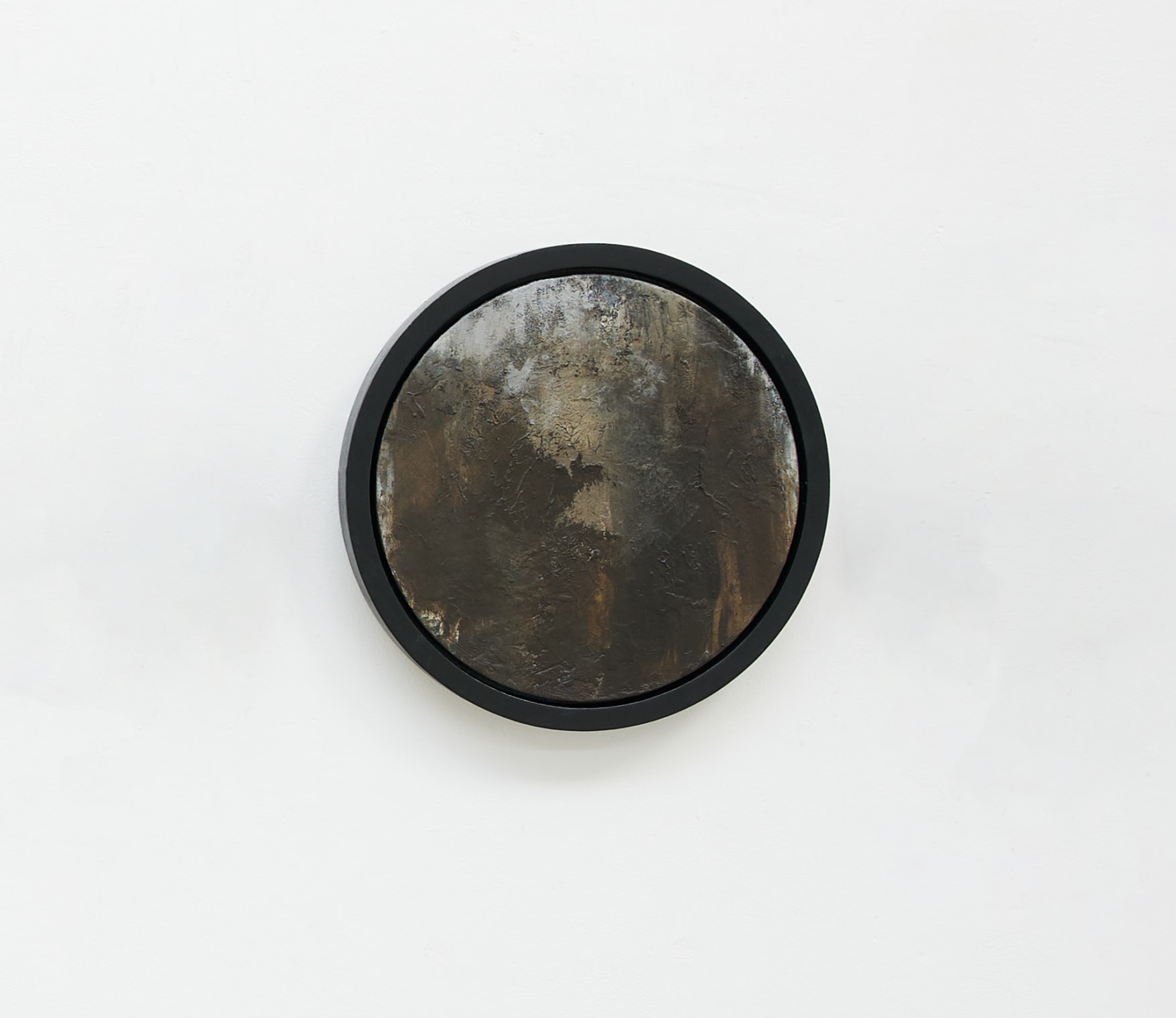 A small circular framed canvas. Brown in palette with a soft appearance.