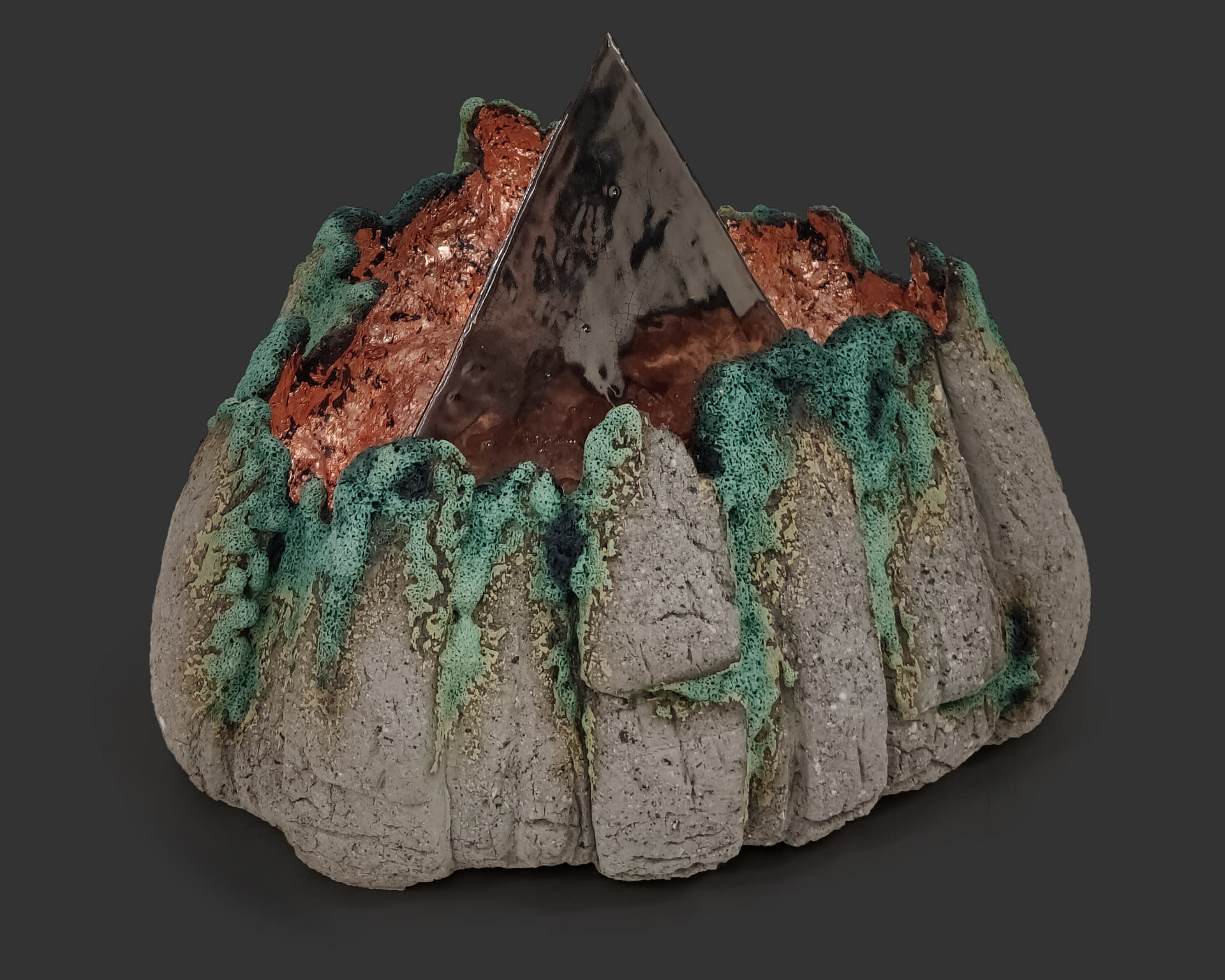 An image of ceramic sculpture by Chloe Lennon with metal copper leaf and volcanic glazes representing nature and industry. 