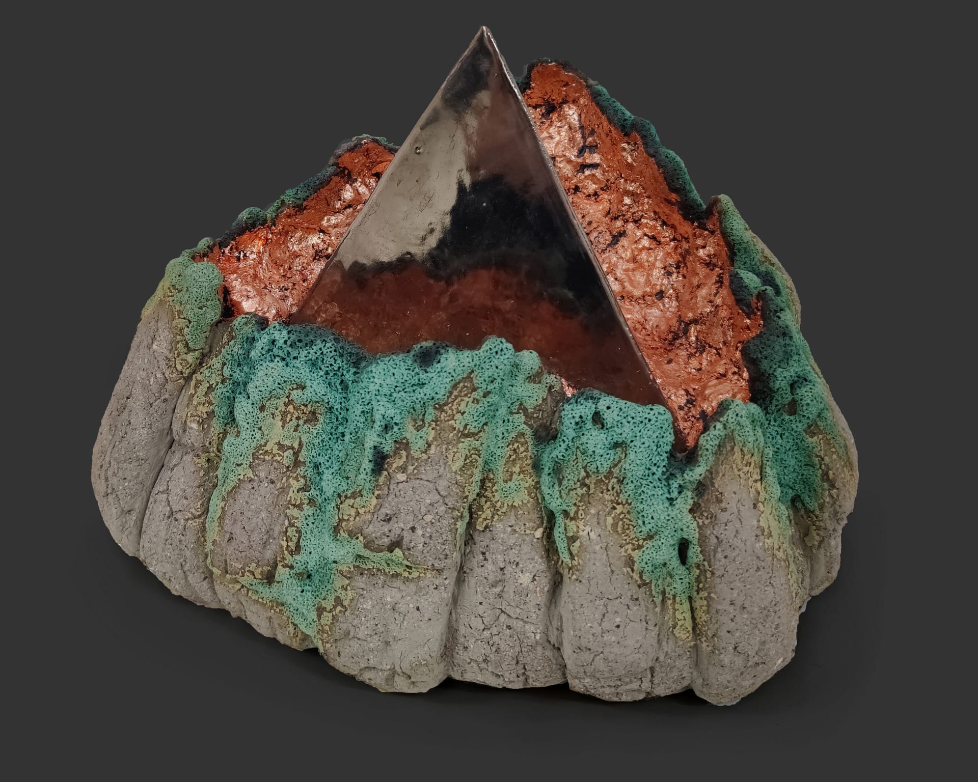 An image of ceramic sculpture by Chloe Lennon with metal copper leaf and volcanic glazes representing nature and industry. 