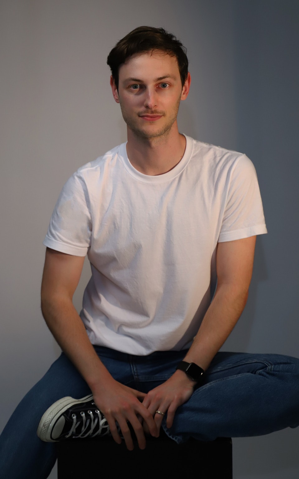 White male portrait with a white shirt and blue jeans