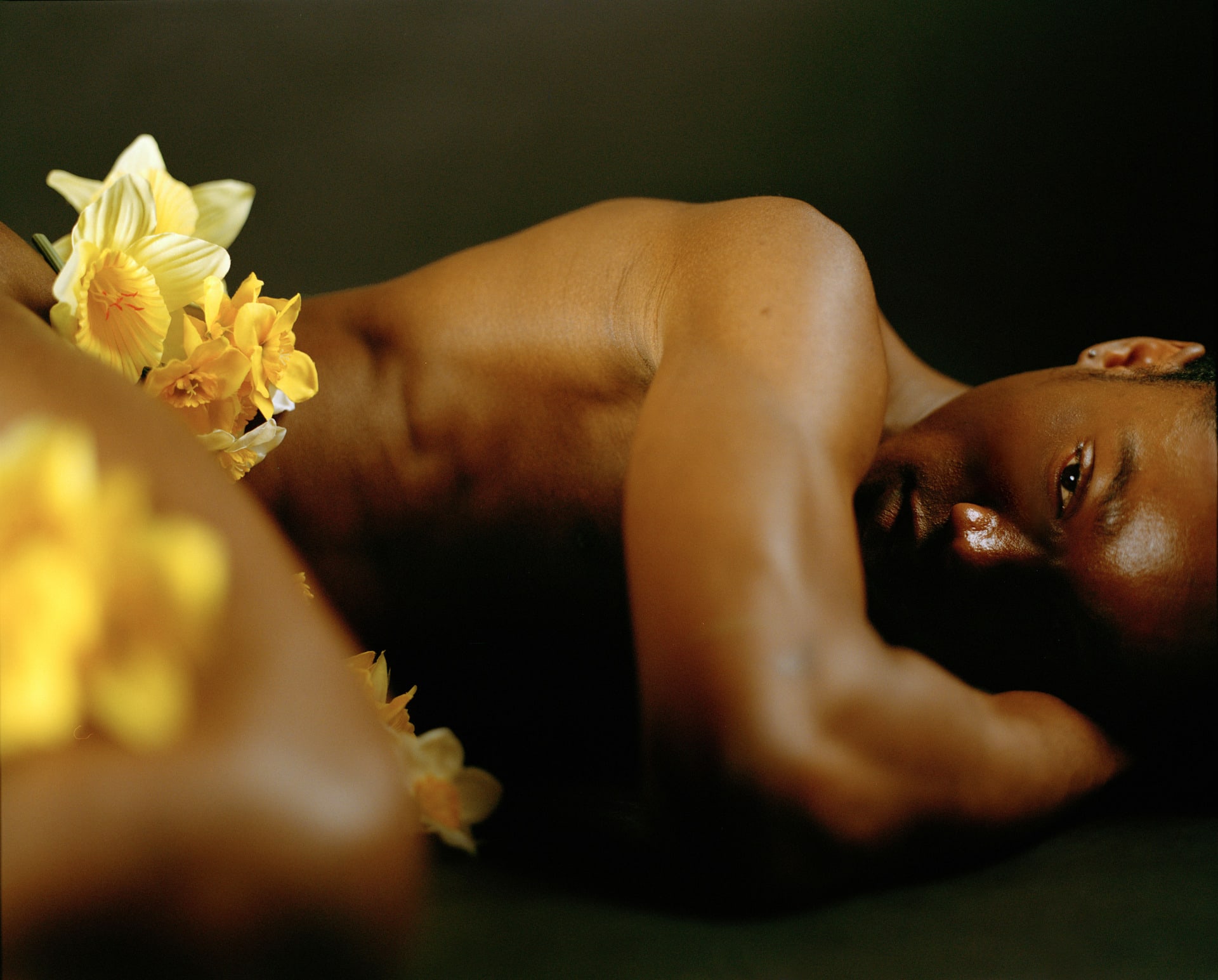  image of a man laying down with daffodils 