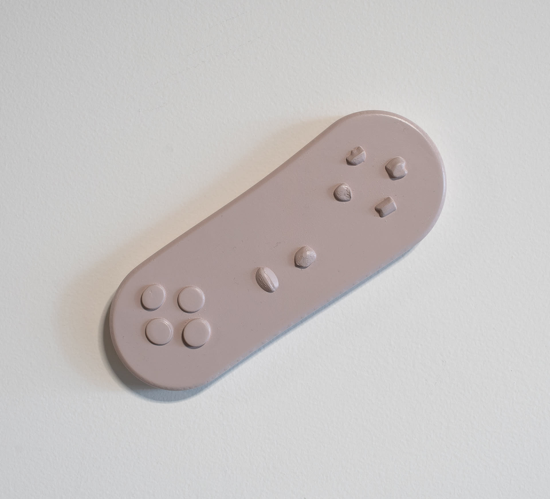 Purple wall-mounted sculpture, pill-shaped with controls.