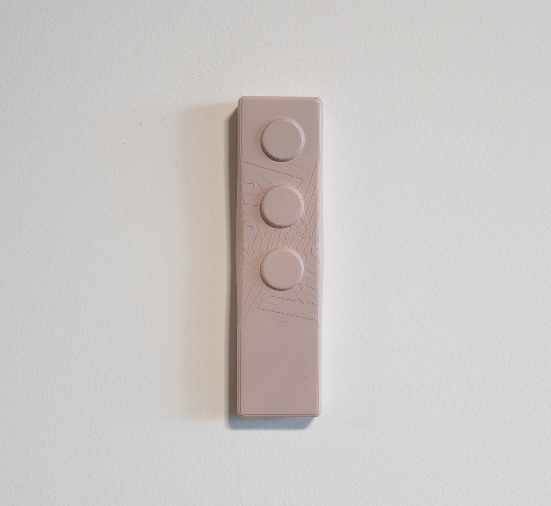 Grey-purple wall-mounted sculpture, rectangular with three circular buttons at top & abstract markings. 