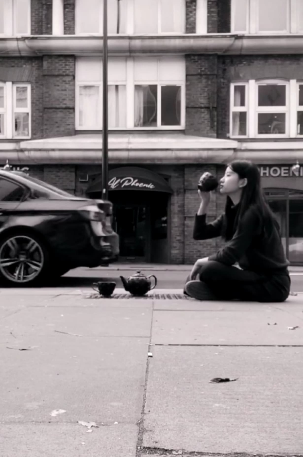 Image of the artist sitting on manhole cover 