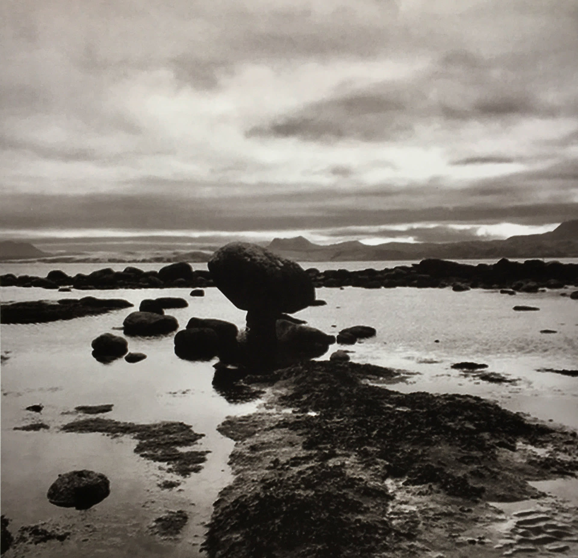 Photographic image of a rock balancing in sepia tones.