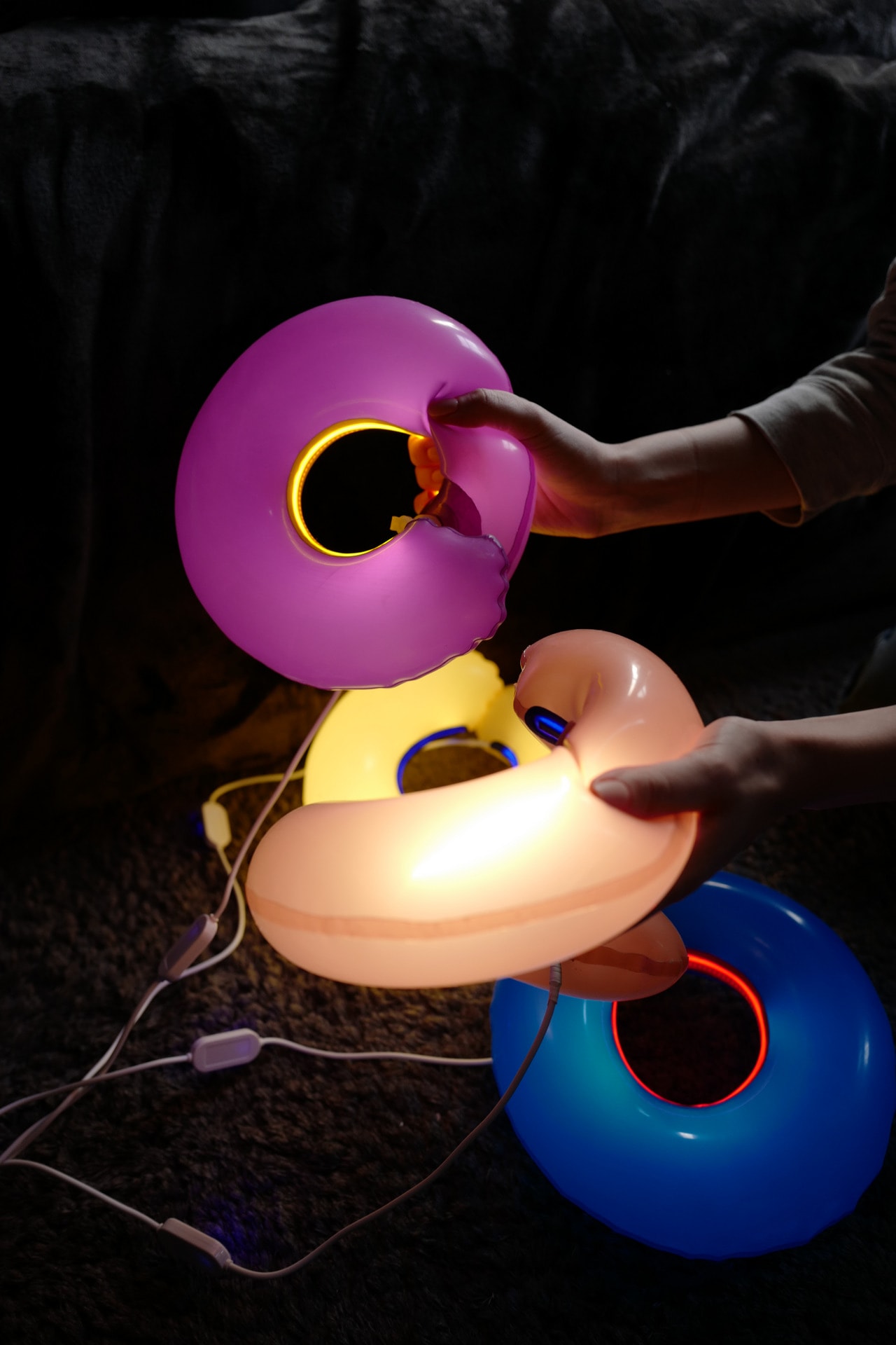 Hand squeezing and turning colorful latex lamps