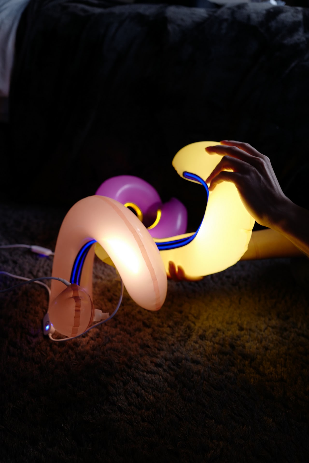 Hand squeezing and turning colorful latex lamps