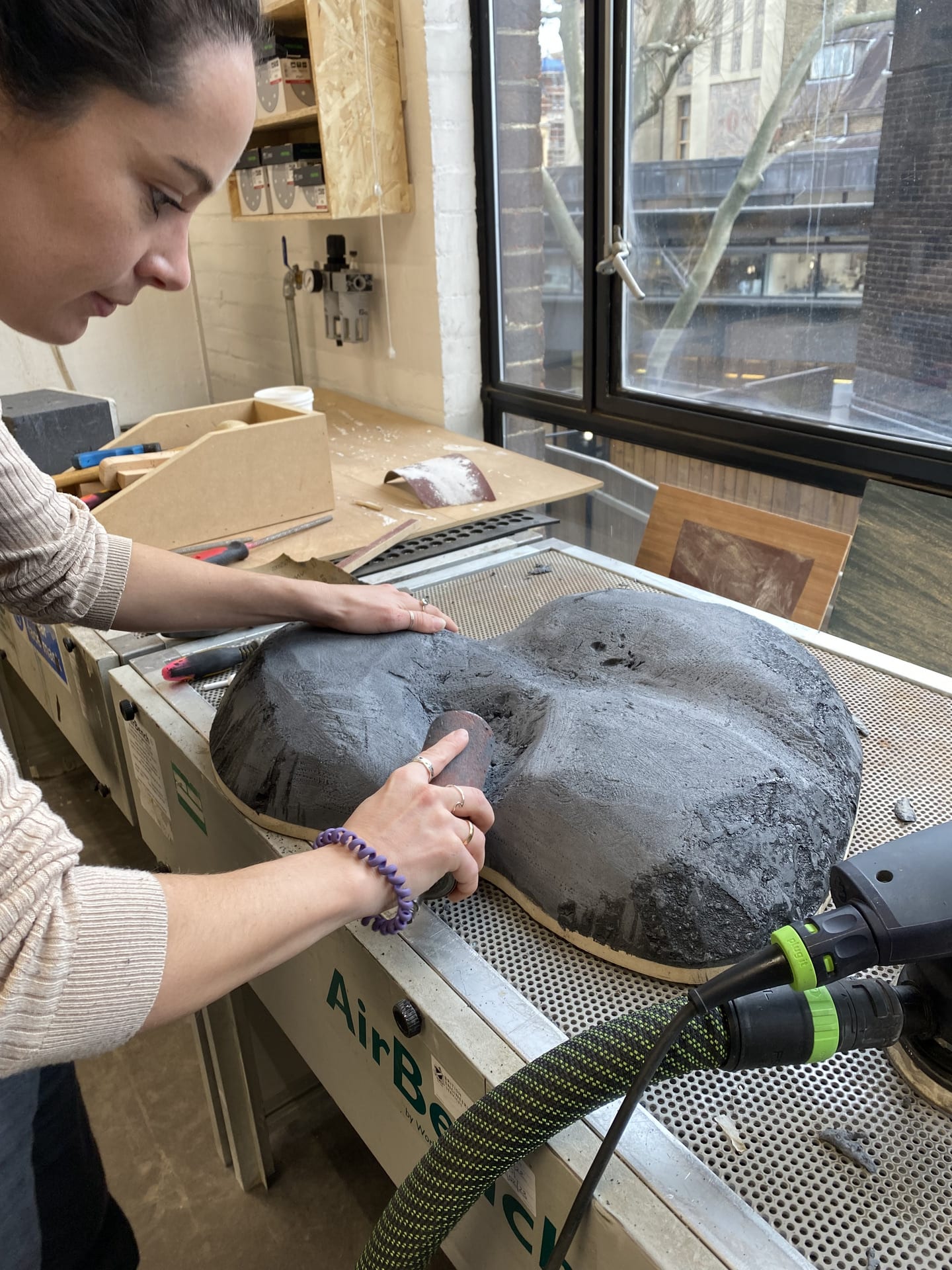 Margo sanding the top of the base