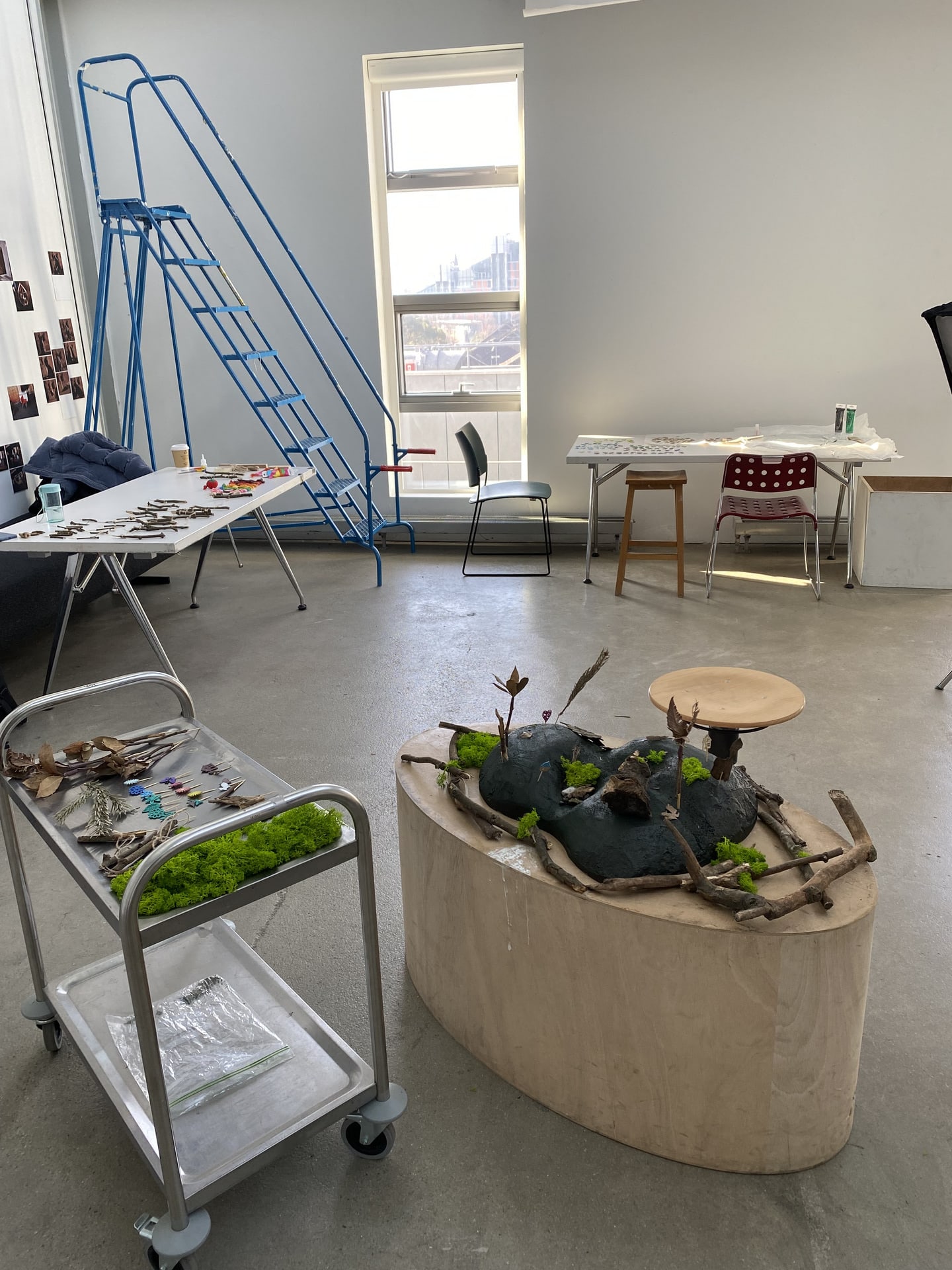 Several tables set up in the photography studio, on which are the model and spread out components that participants could add.