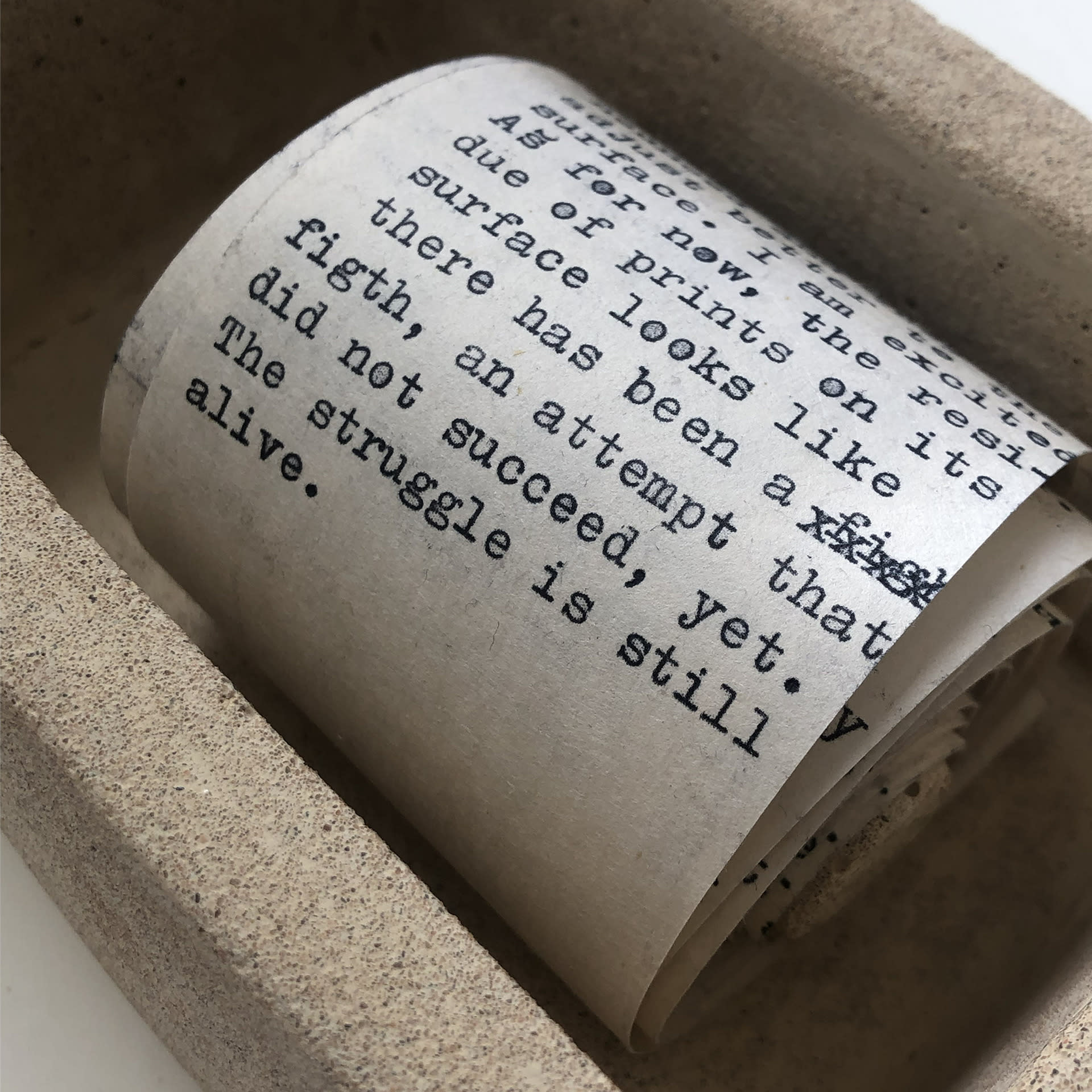 Typewritten roll of text inside a Jesmonite box