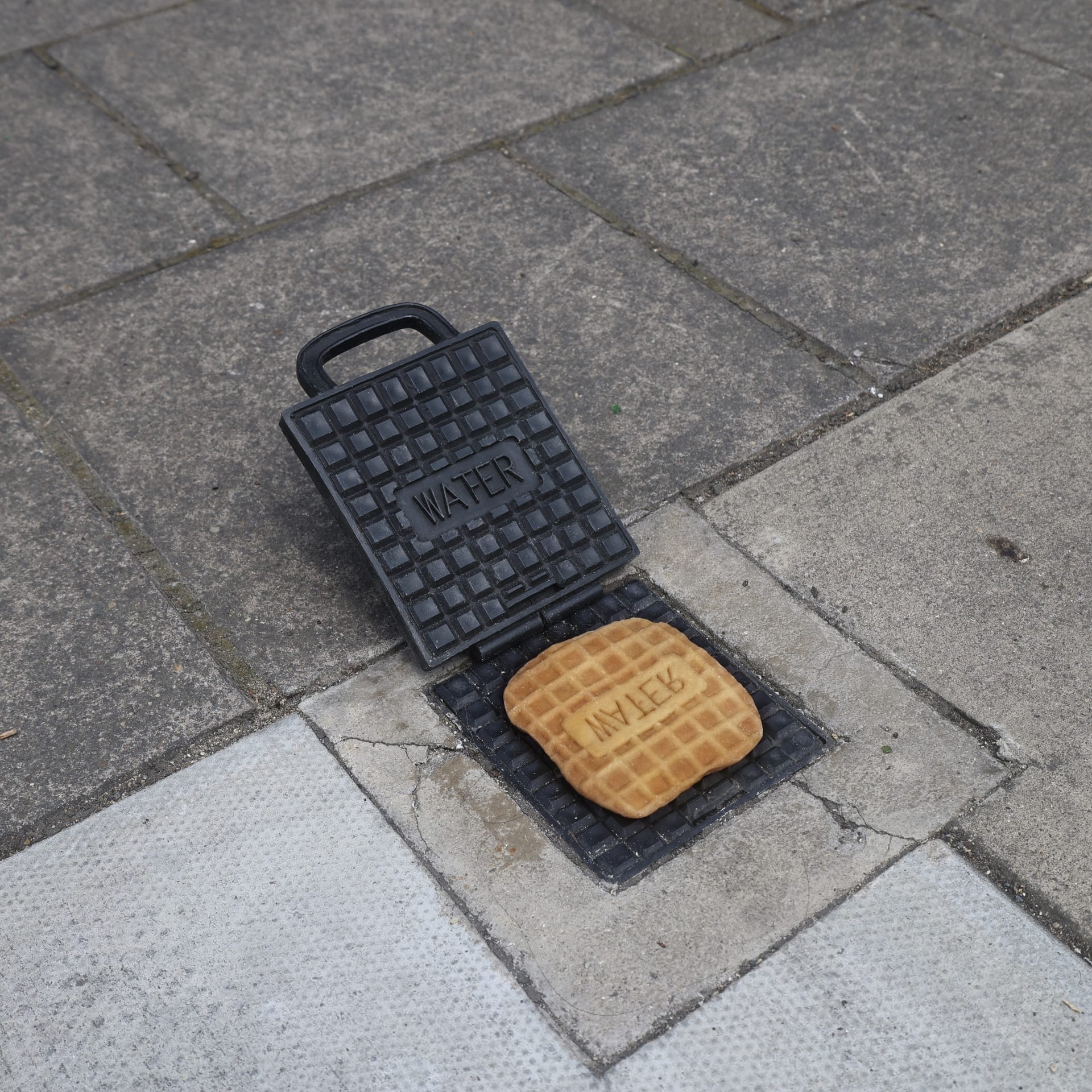 A humour collage of a wafer maker with the water stopcock cover at London street, made with casted metal. I placed a wafer on th