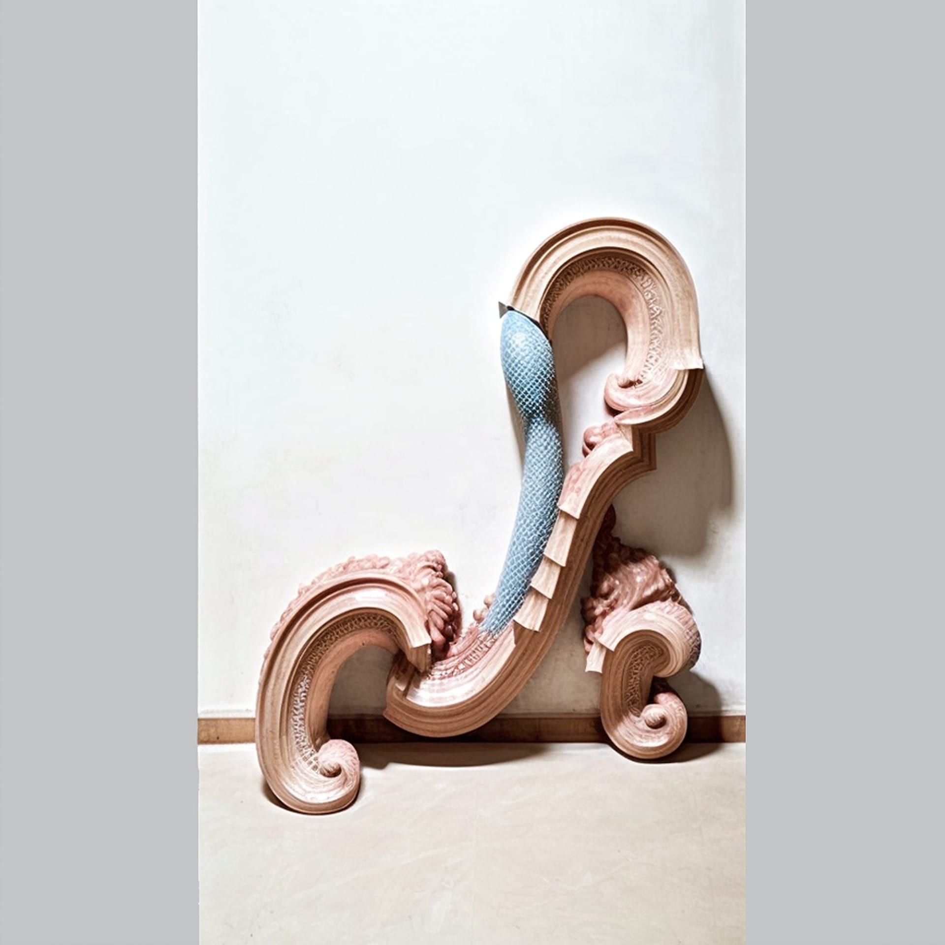 This image is a sculpture with a wavy shape and is predominantly pink and beige in color.