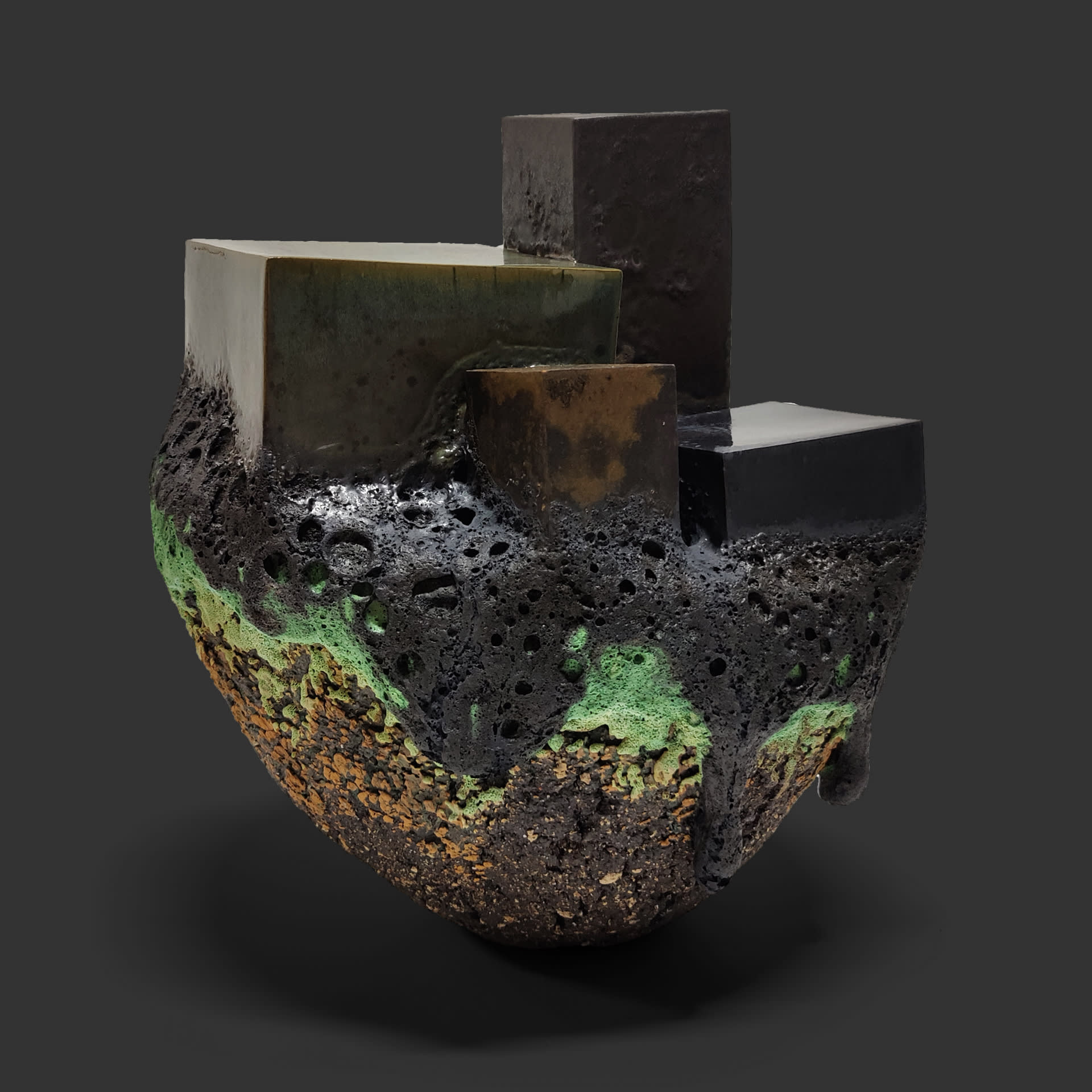 An image of ceramic sculpture by Chloe Lennon with metal copper leaf and volcanic glazes representing nature and industry. 