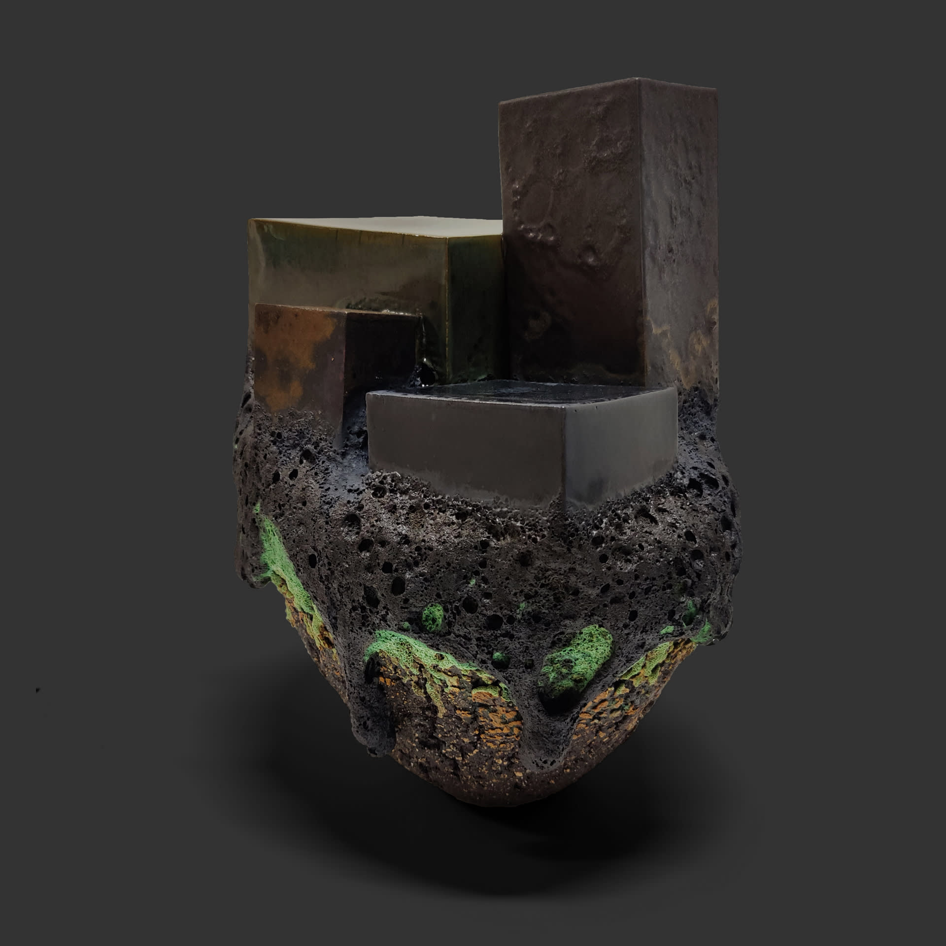 An image of ceramic sculpture by Chloe Lennon with metal copper leaf and volcanic glazes representing nature and industry. 
