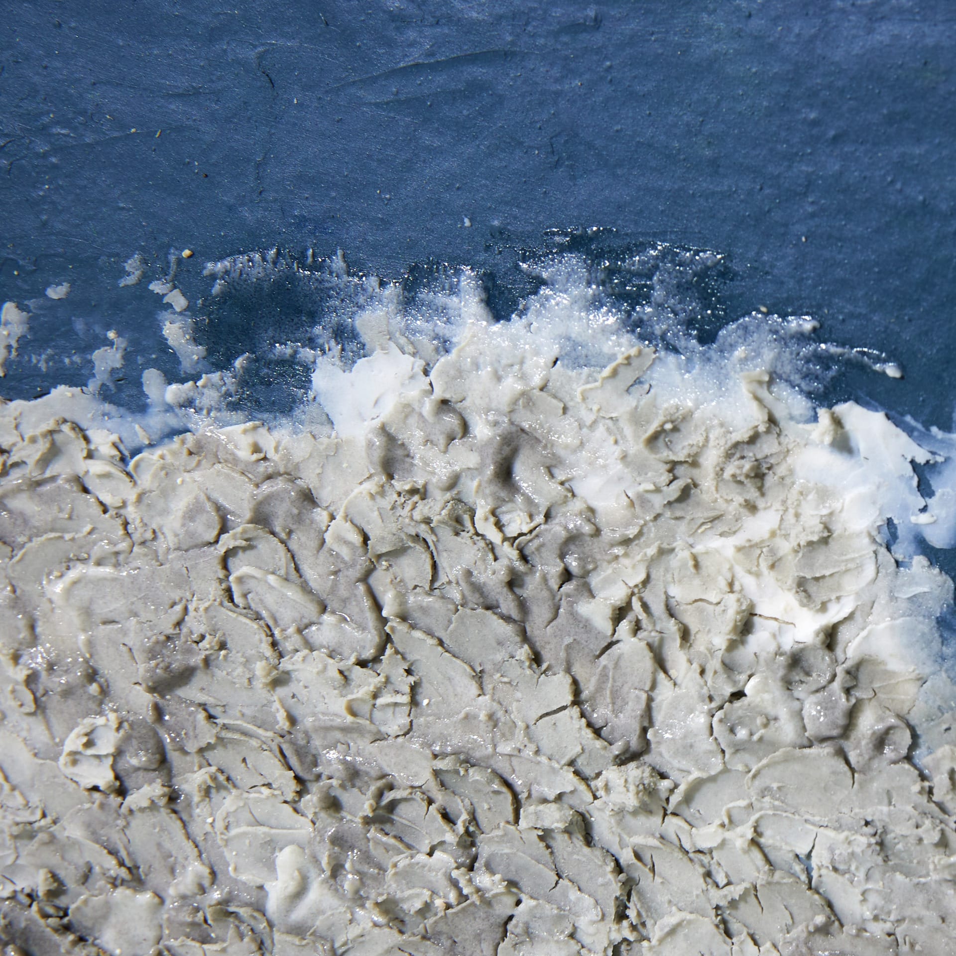 deep blue coloured surface covered with white and grey texture of clay and glaze.