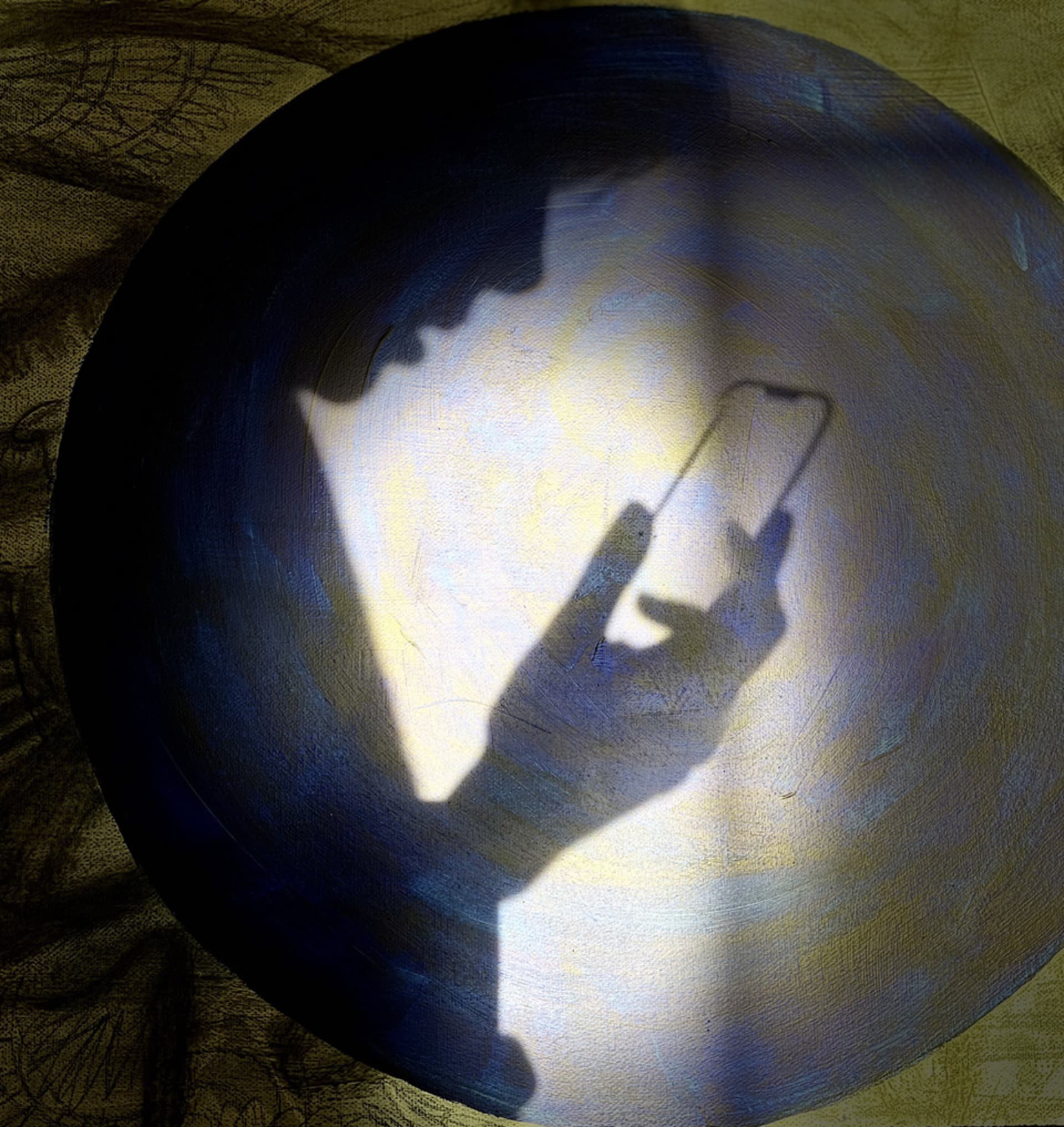 Silhouette of artist against a painting of a blue circle, holding a smart phone which seems to be transparent.