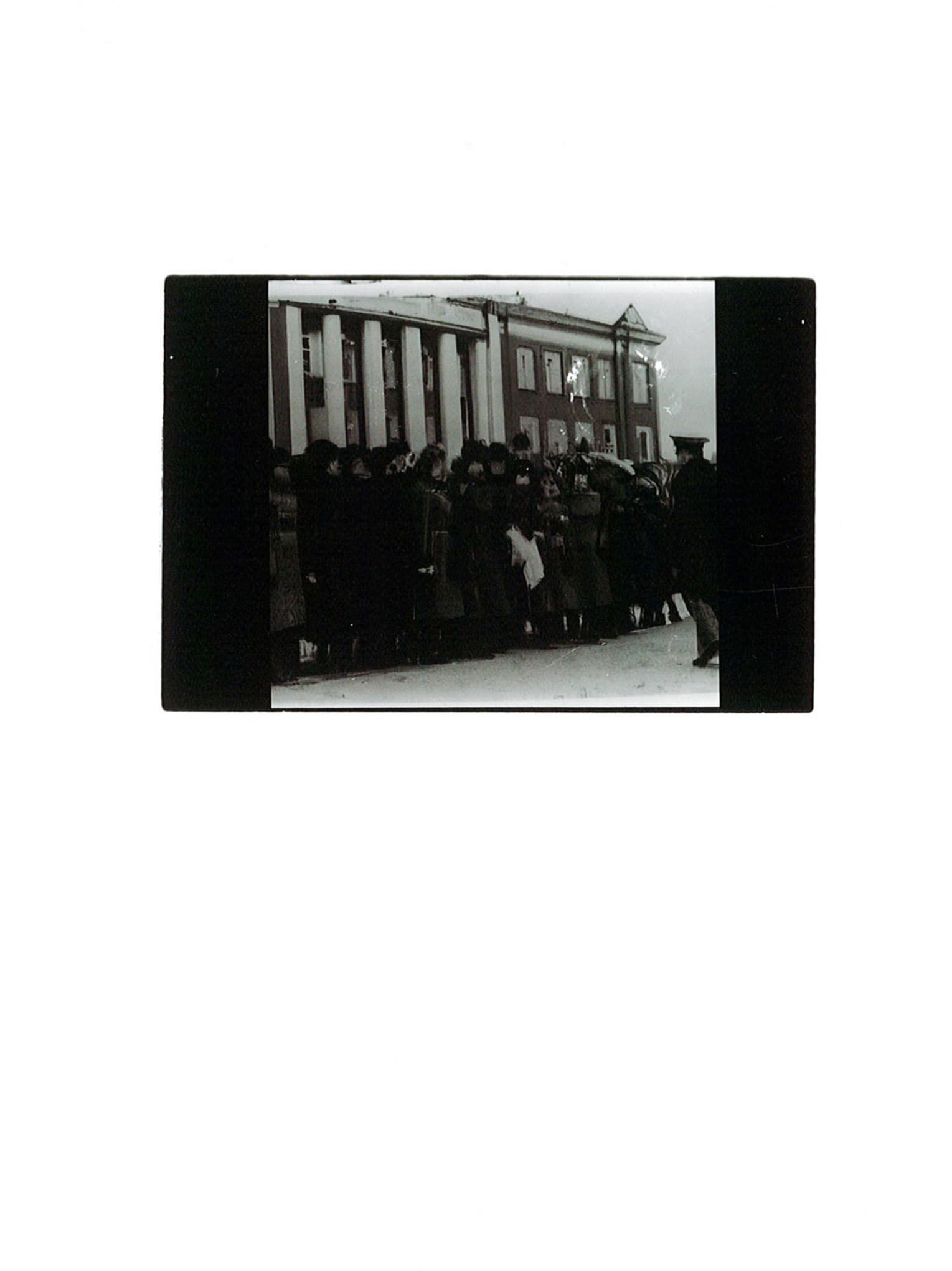 black and white darkroom print of a crowd with faces blurred due to AI-generation