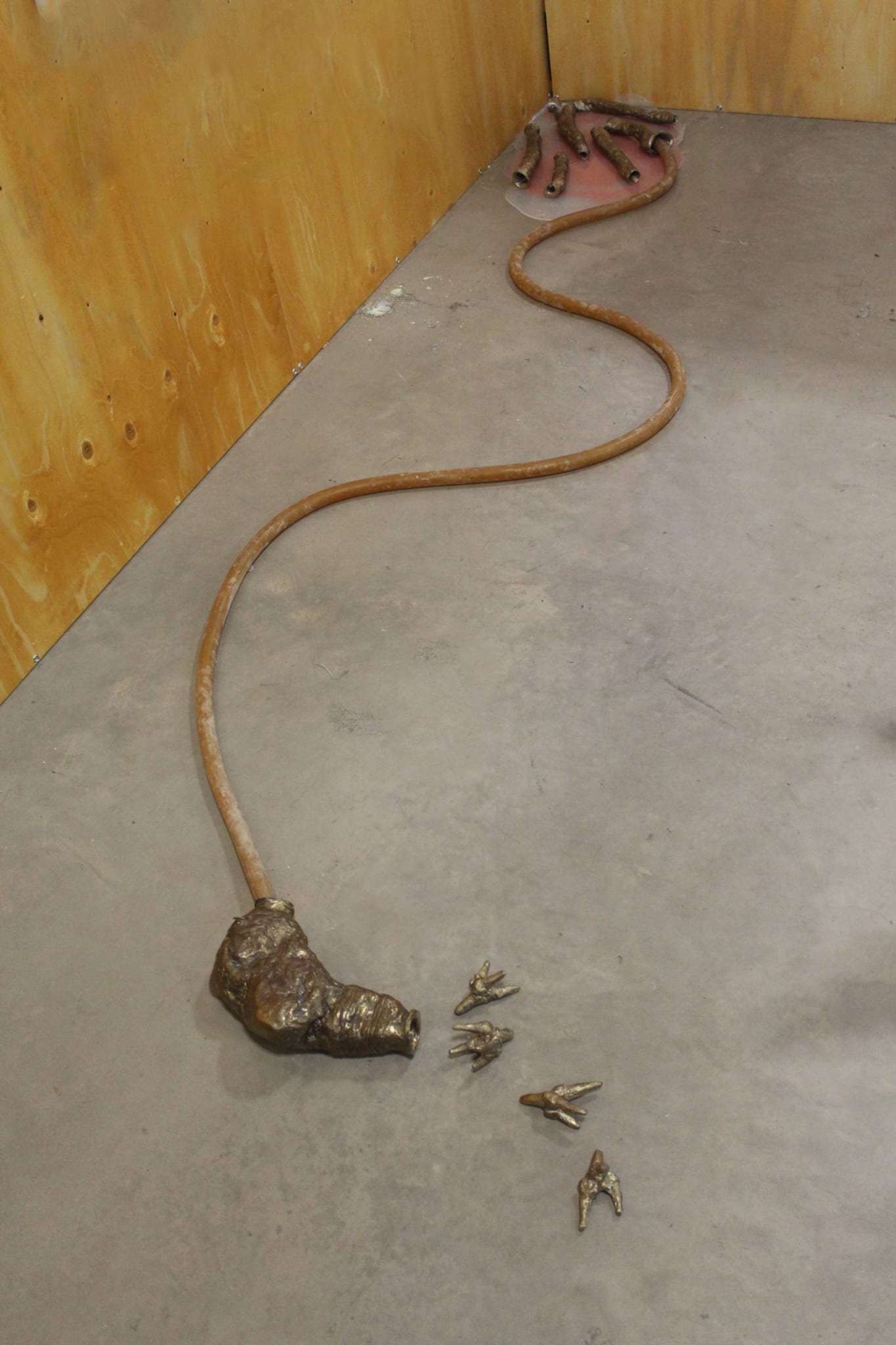 floor piece consisting of 11 bronze parts and one rubber tube connecting the floor piece to the installation