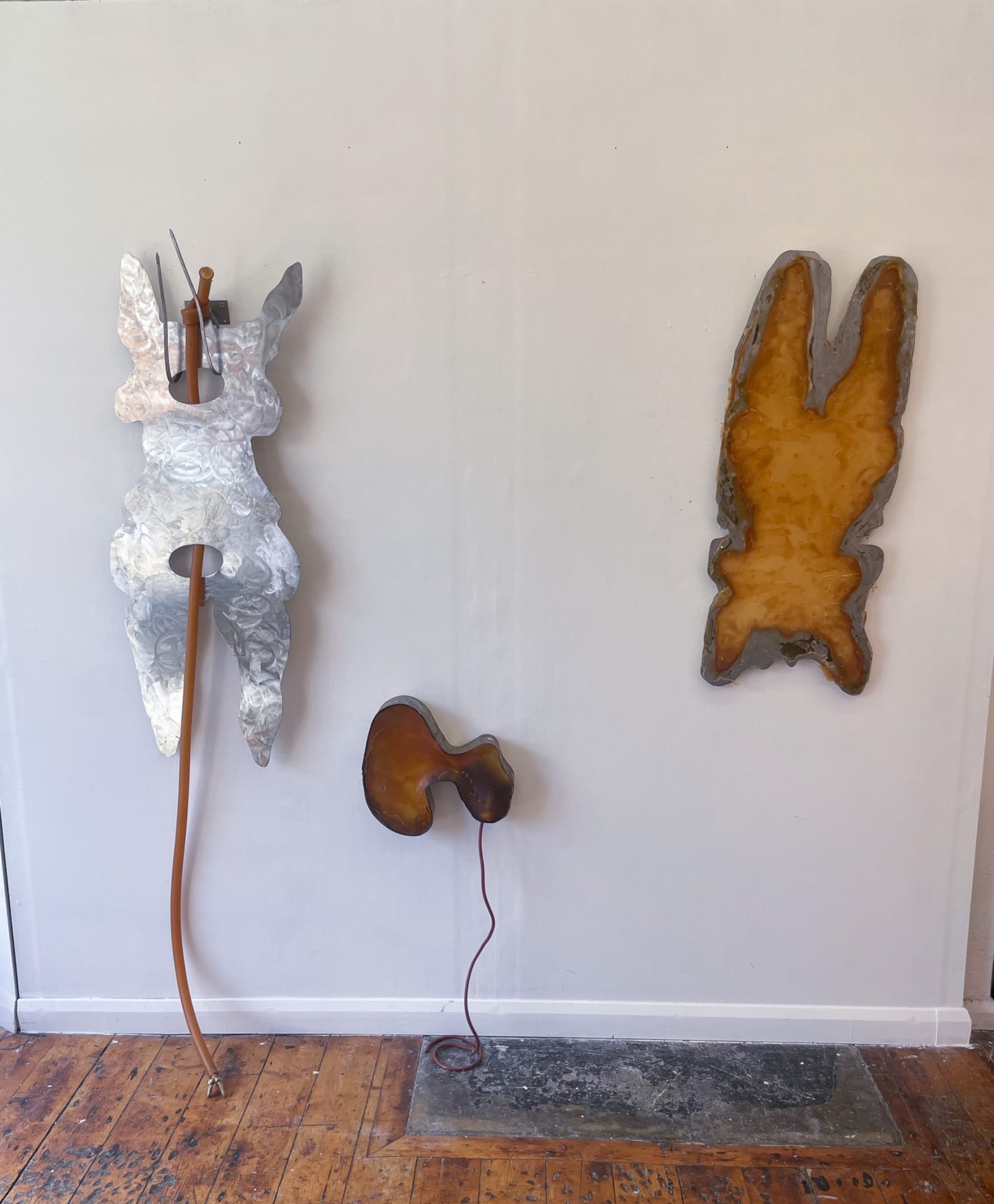 three wall based sculptures of abstracted female bodies