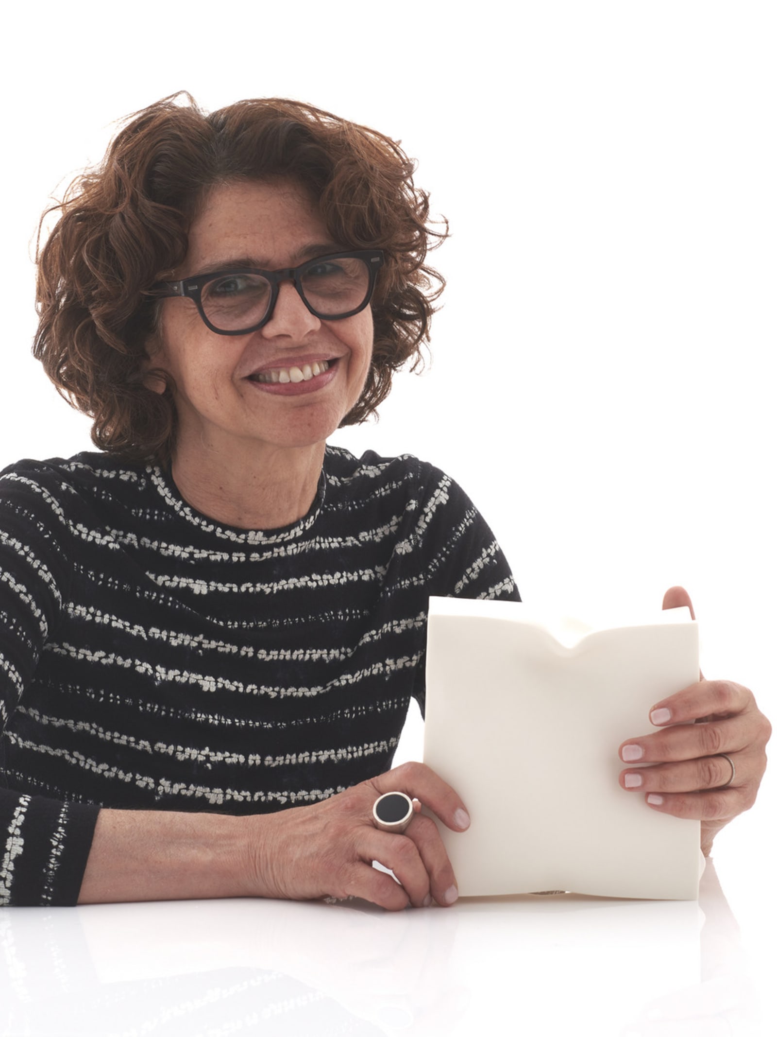 Portrait of the maker with her ceramic piece in hand