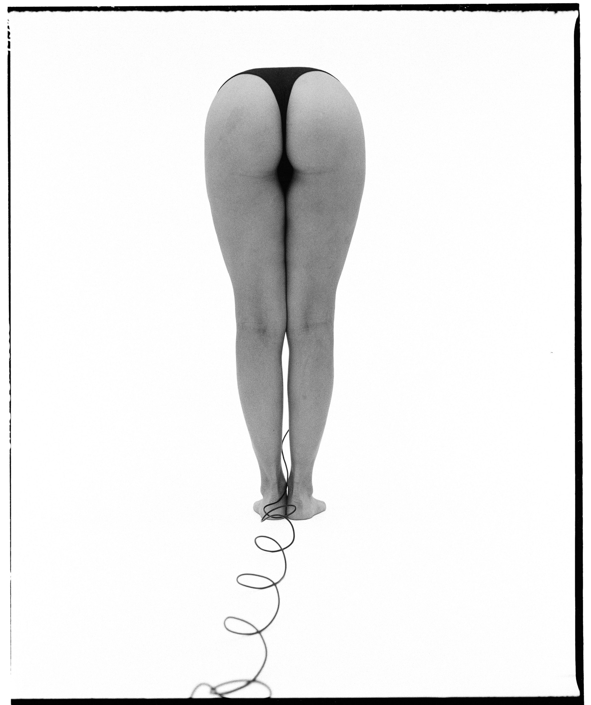 black and white self-portrait, facing away from the camera, leaning over
