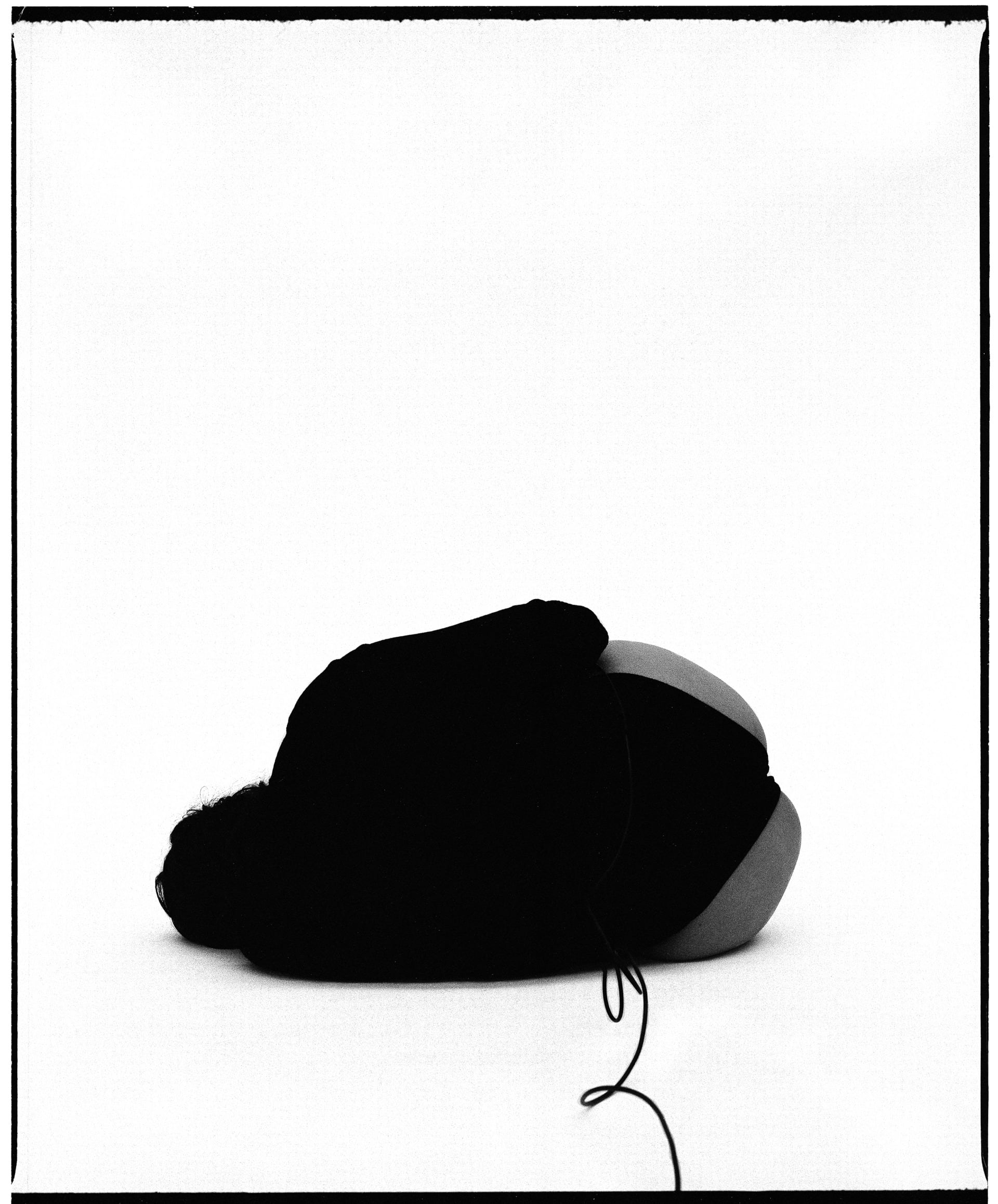 black and white self-portrait laying on side with back face away from the camera
