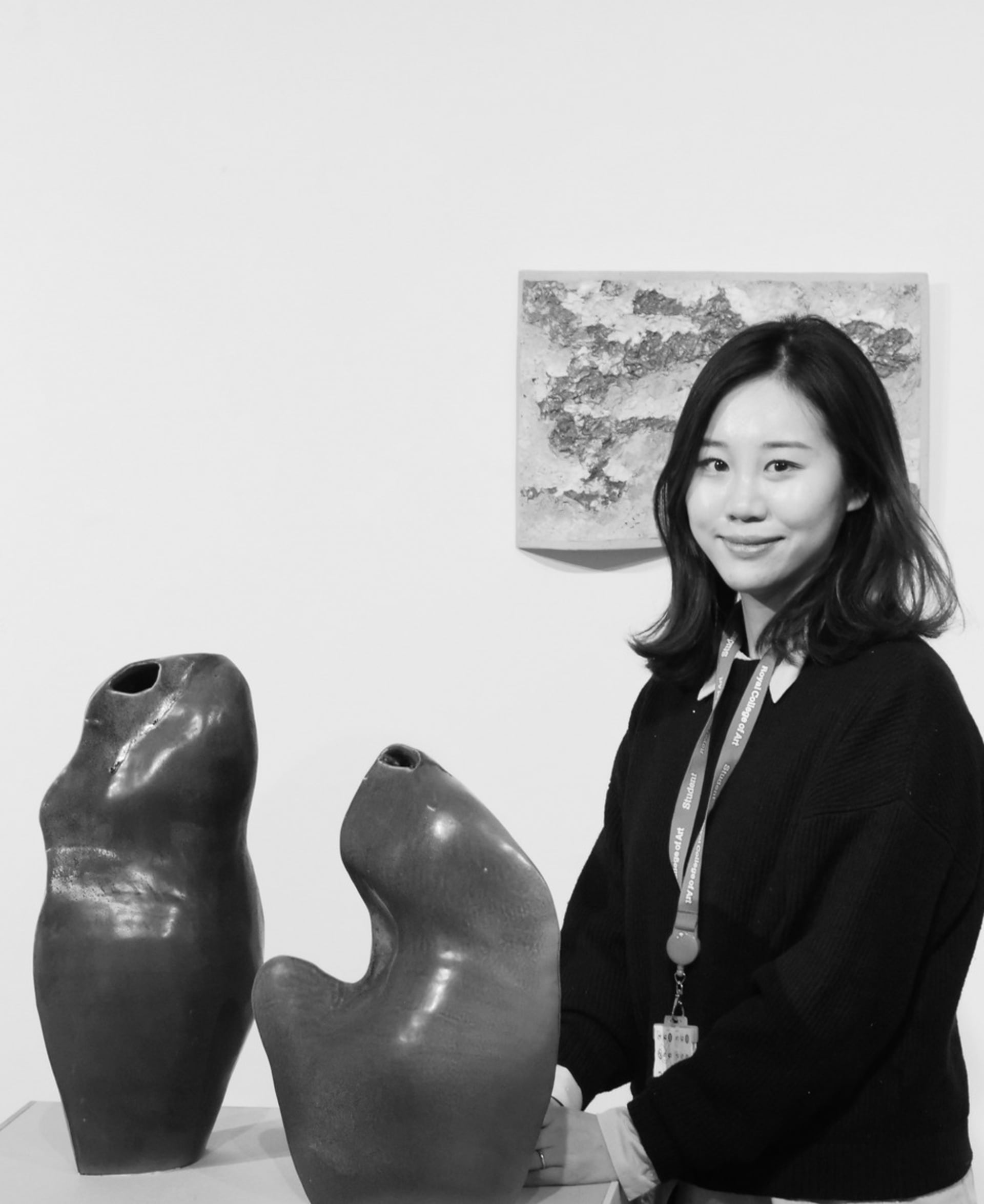 Soobin Lee stands by her artwork, ceramic vessels and wall mount painted ceramic.