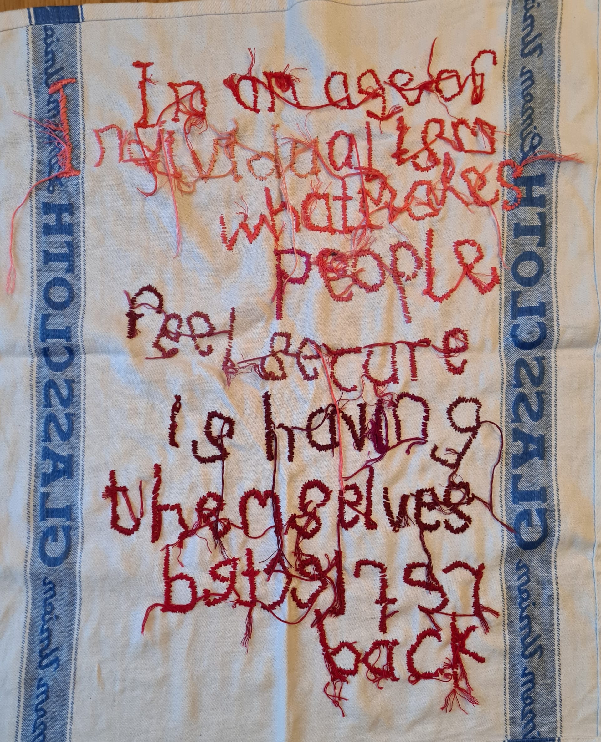 the reverse of glass cloth embroidered with a quote by Adam Curtis 