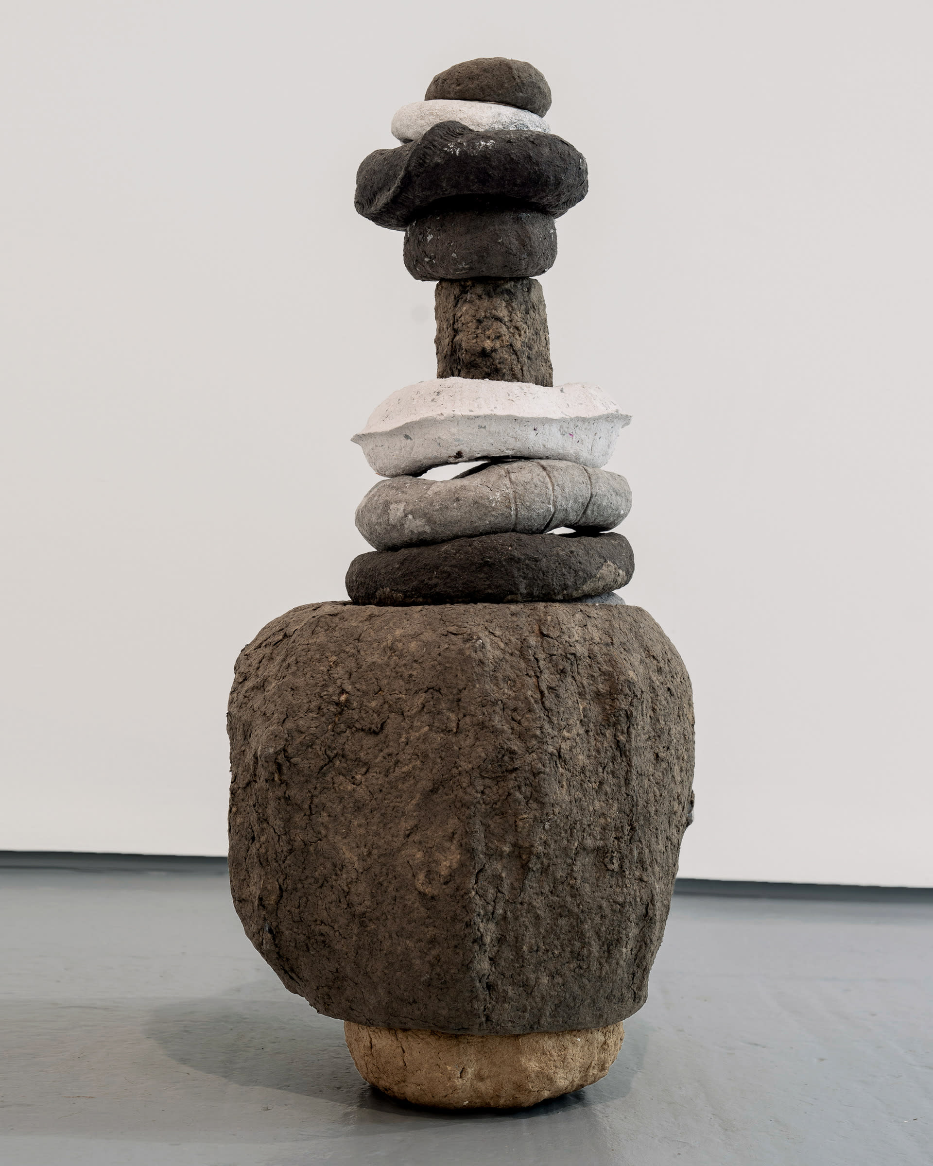 Sculpture, stack of textured paper pulp rings brown black white