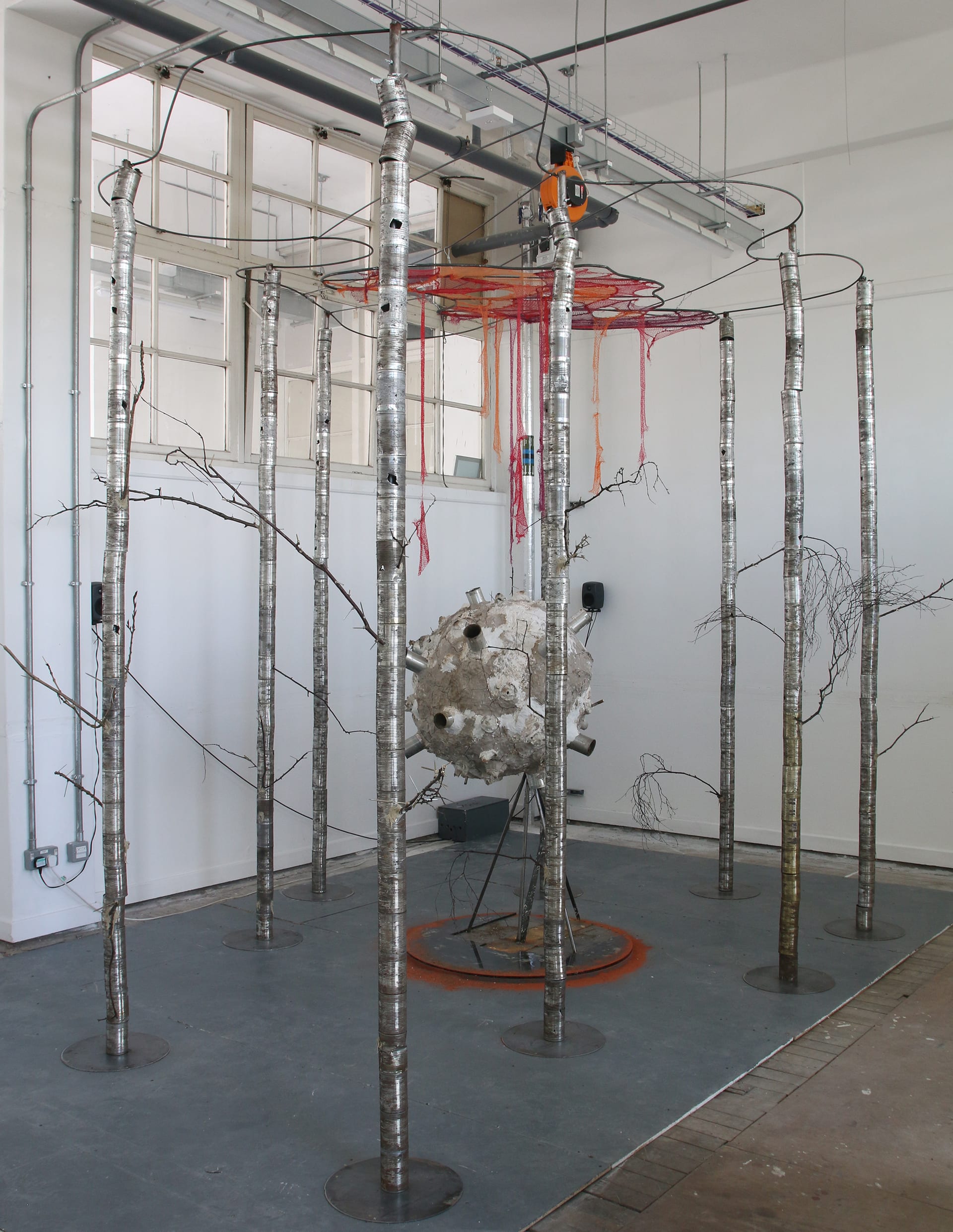 A final photo shows the overall structure of the installation, which resembles a forest or scaffolding structure.