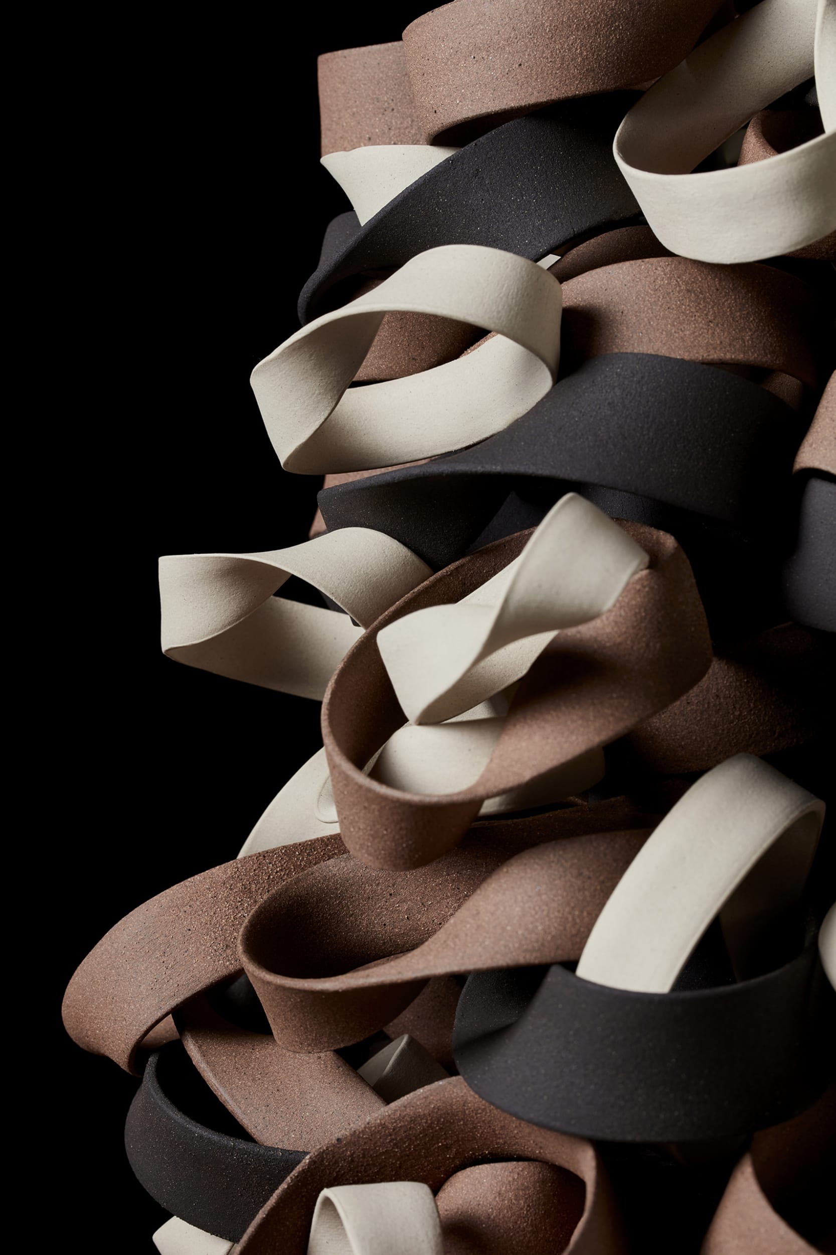 twisted bands of clay balanced and stacked, warped and shifted