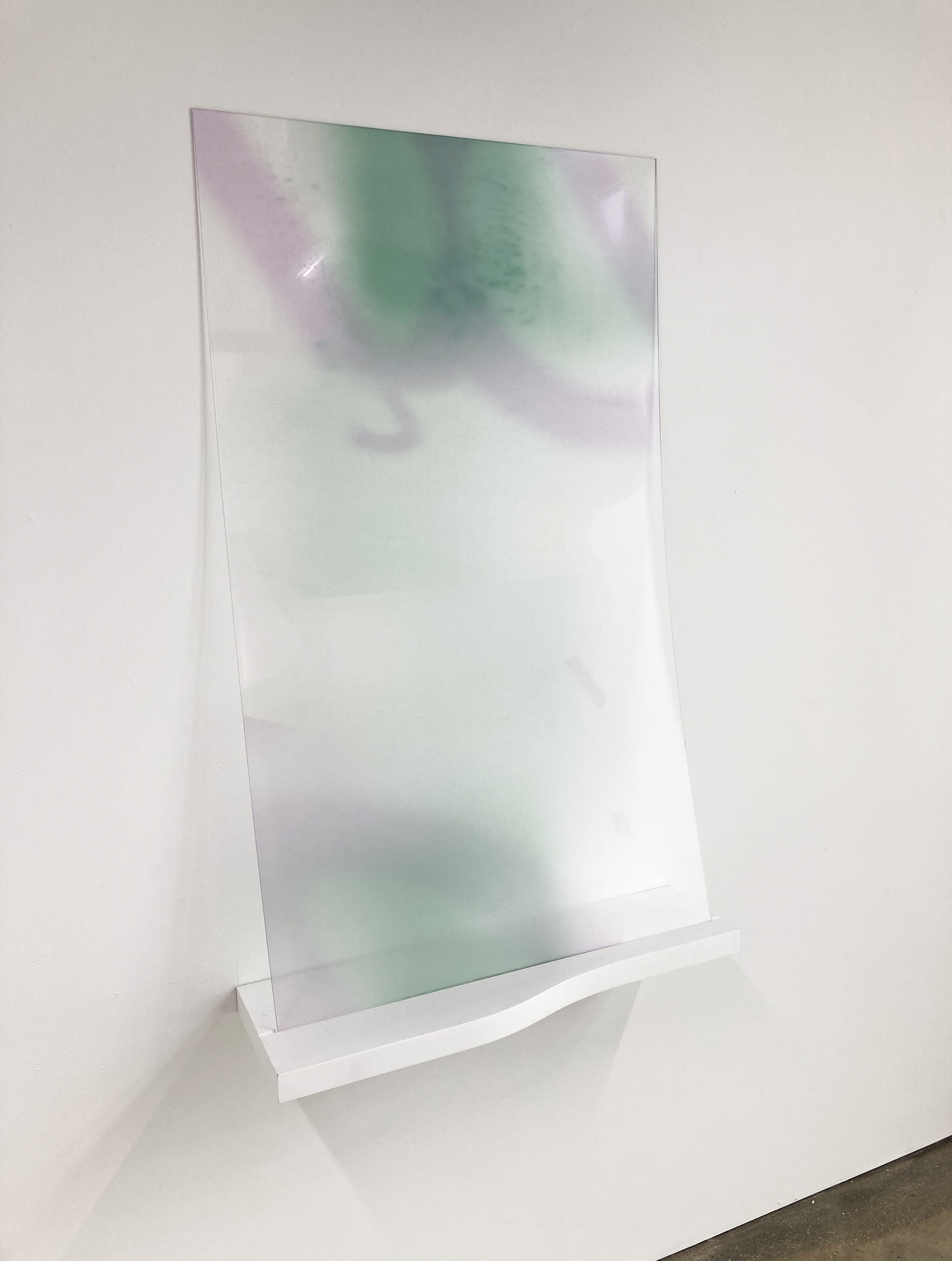 A sheet of acrylic printed with a green background and two purple D shaped forms at the top.