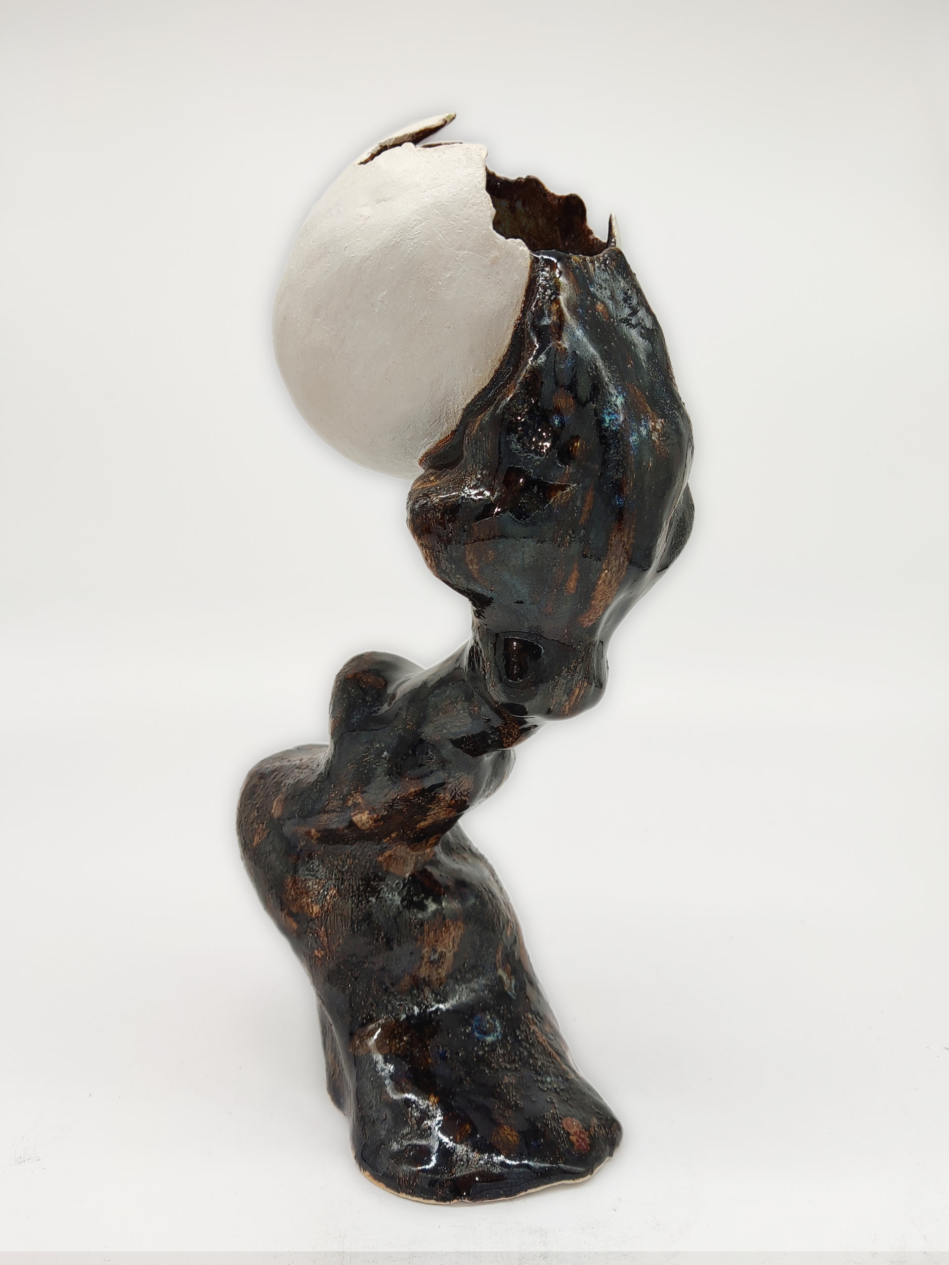 A egg shape sculpture with fluid part support it