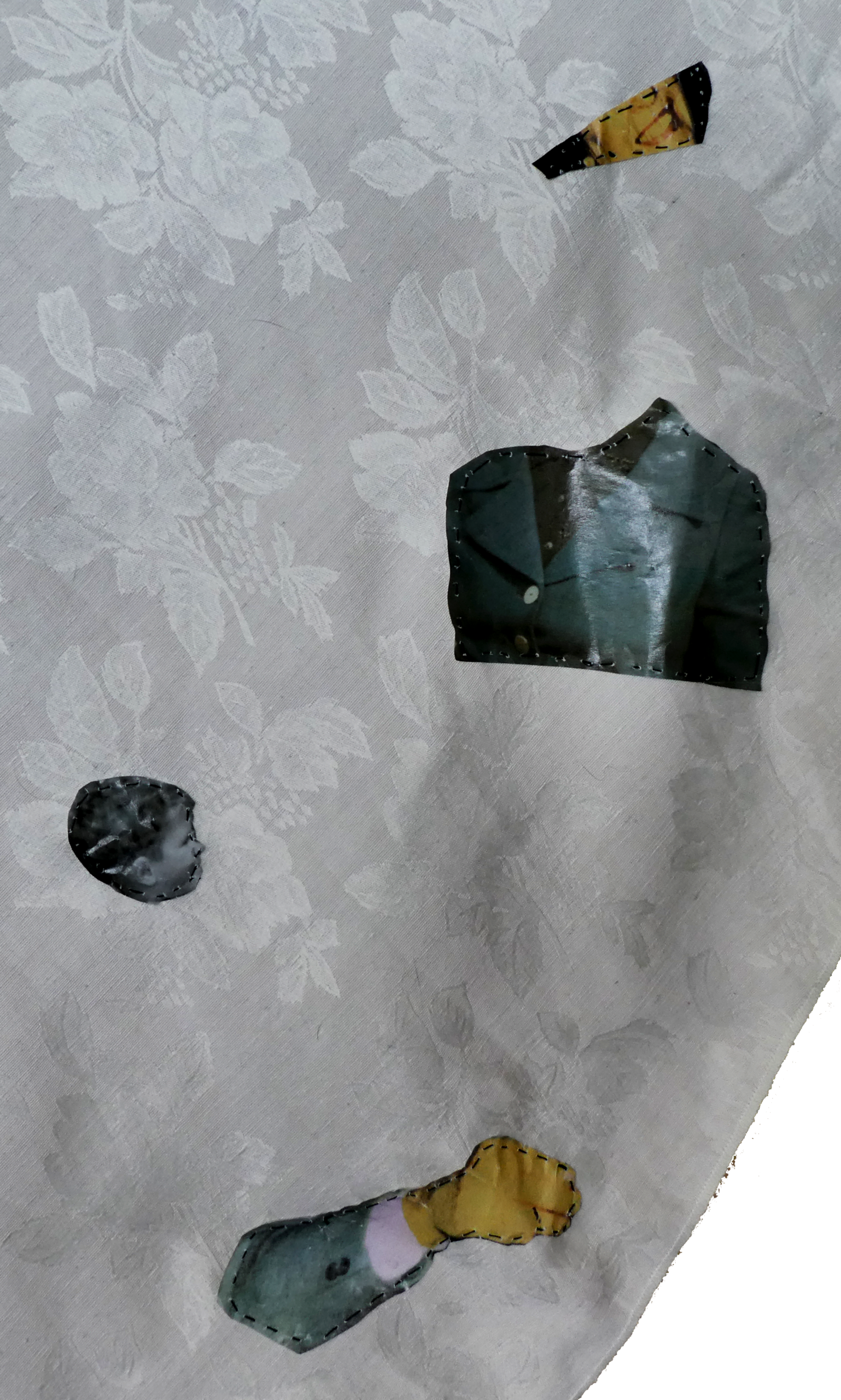 Tablecloth detail - hand-stitched images of fragments of face and a torso