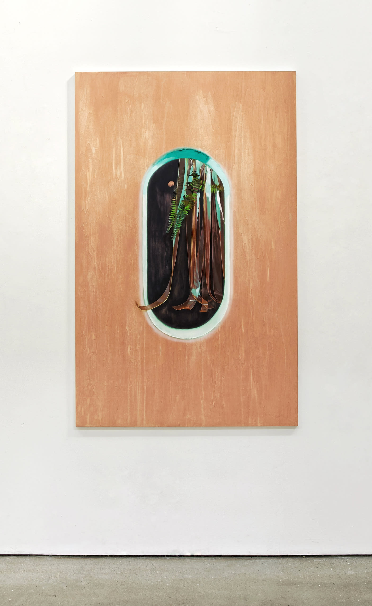 a large wooden peach painted panel with a pill shaped window.  Within the window are PVC strips hanging down with a fake plant