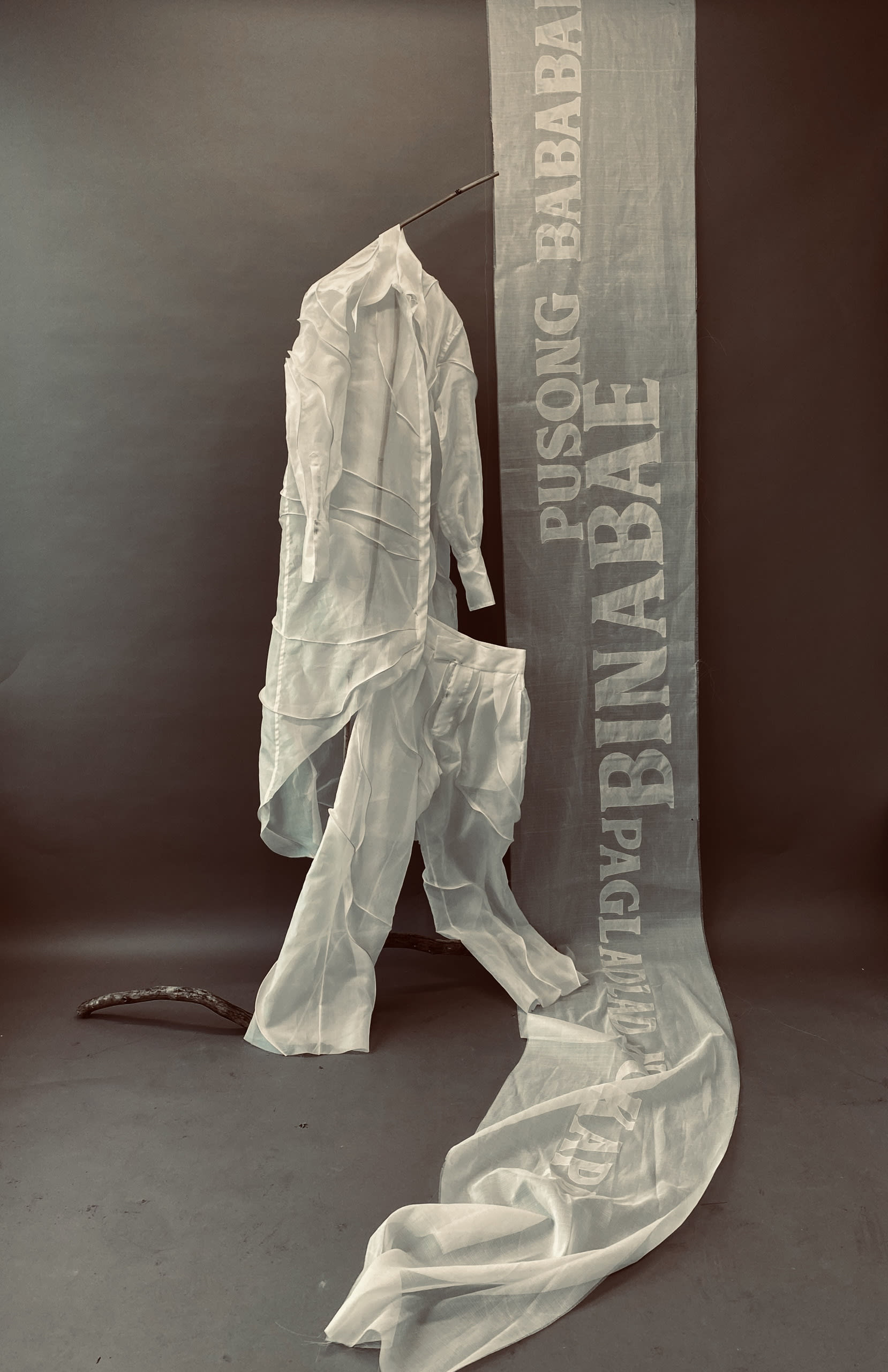 Rattan and piña shirt and trousers with banner of gay sayings. 