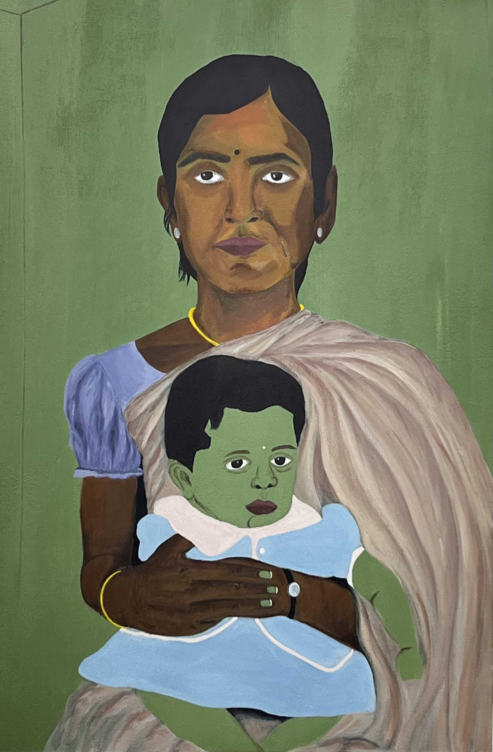 A lady seated with a saree staring at the viewer with a girl baby on her merging with the green colour of the background