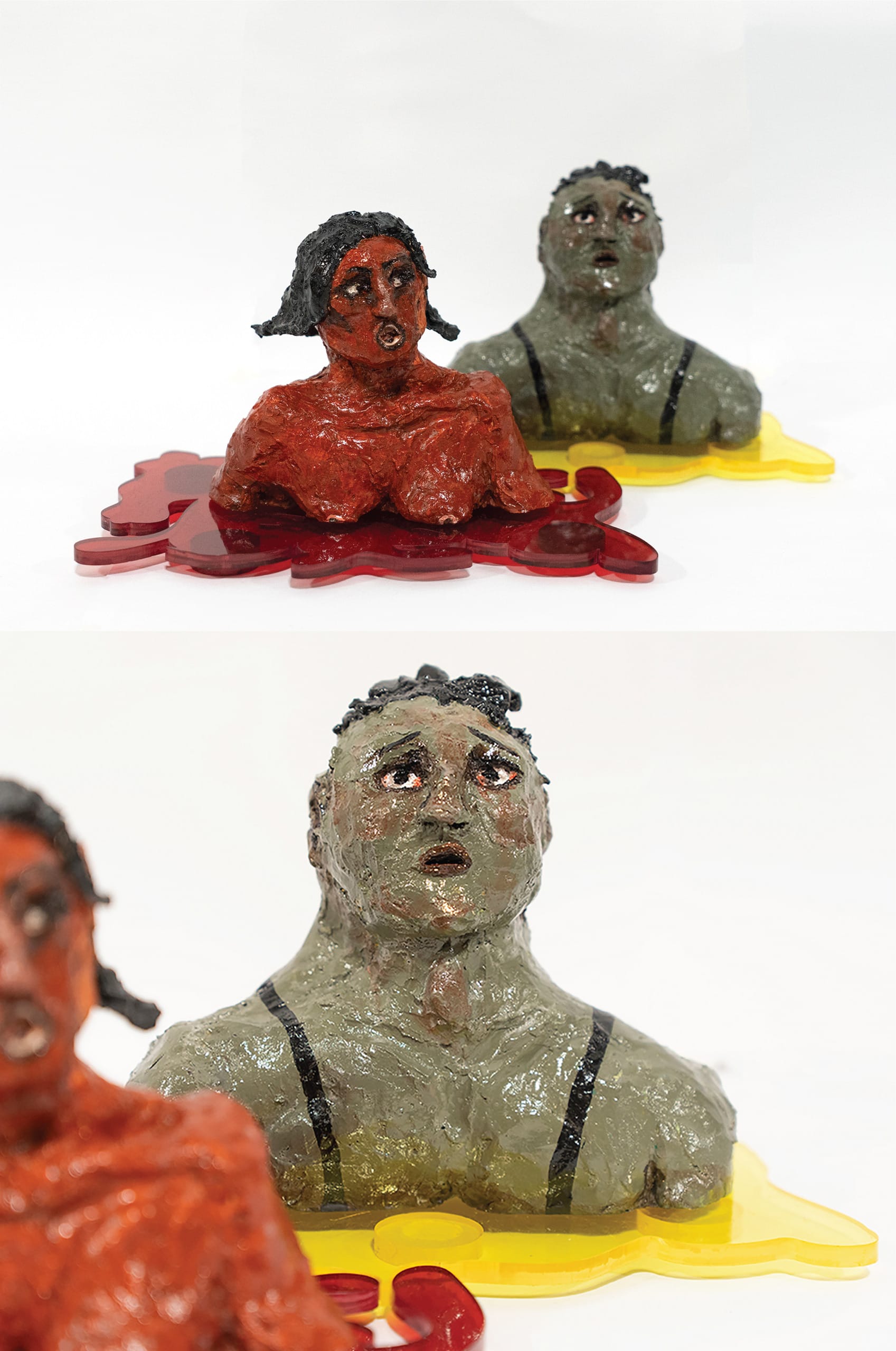 Two ceramic sculptures painted in red and green, placed on two ketchup and mustard coloured acrylic pieces 