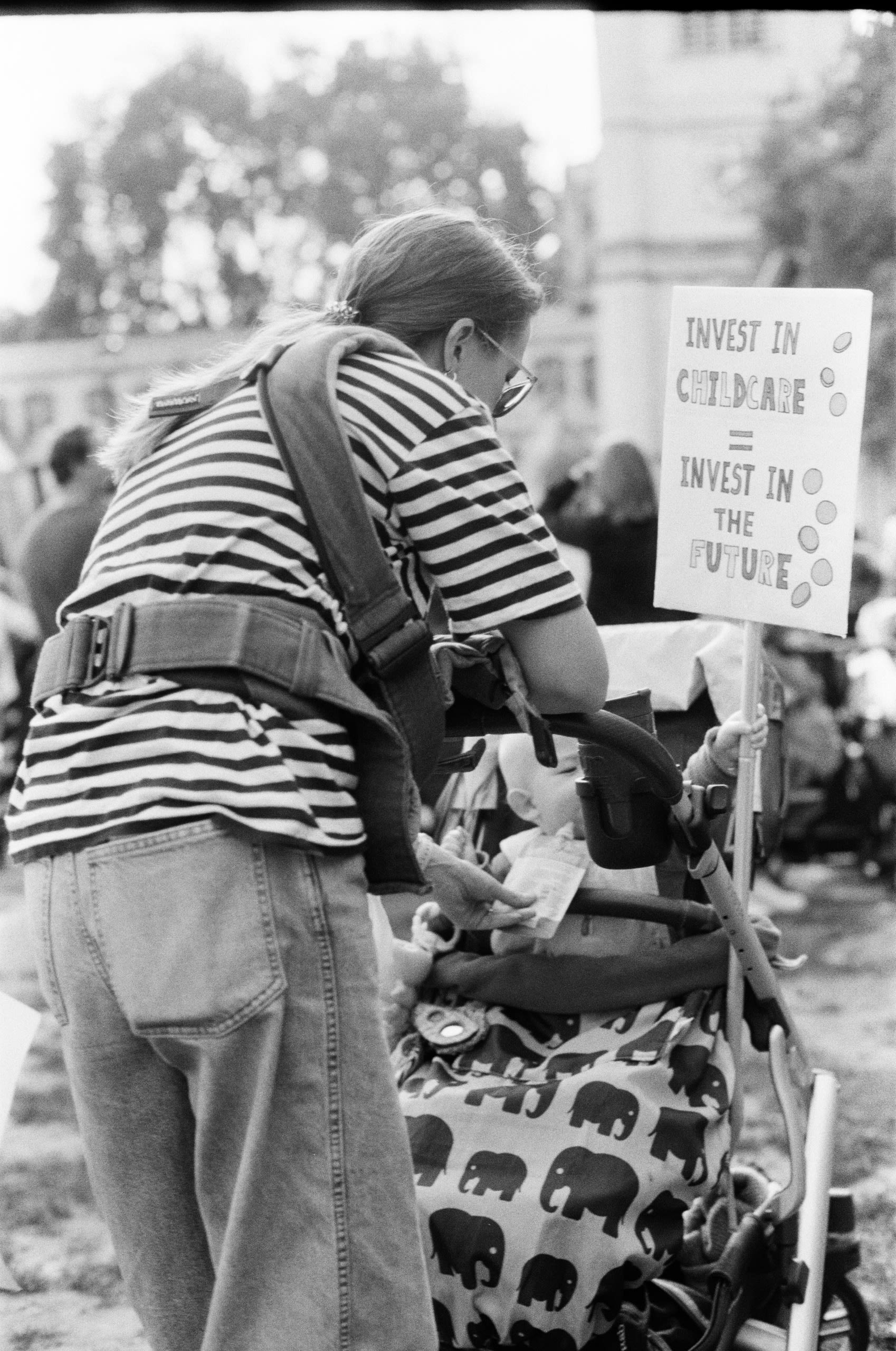 Mother feeding baby holding protest sign