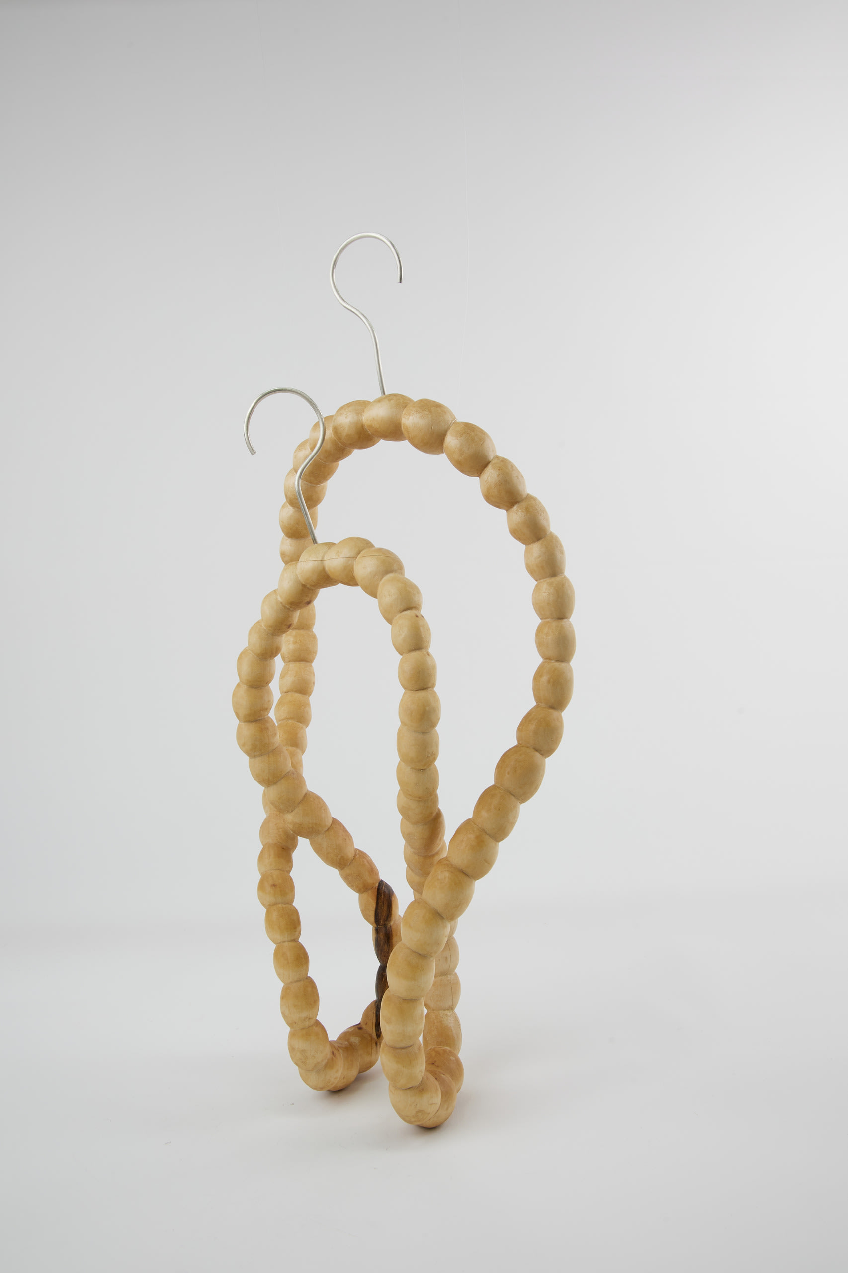 a long string of hand-carved wooden pearls from a whole block of wood with silver hooks on top