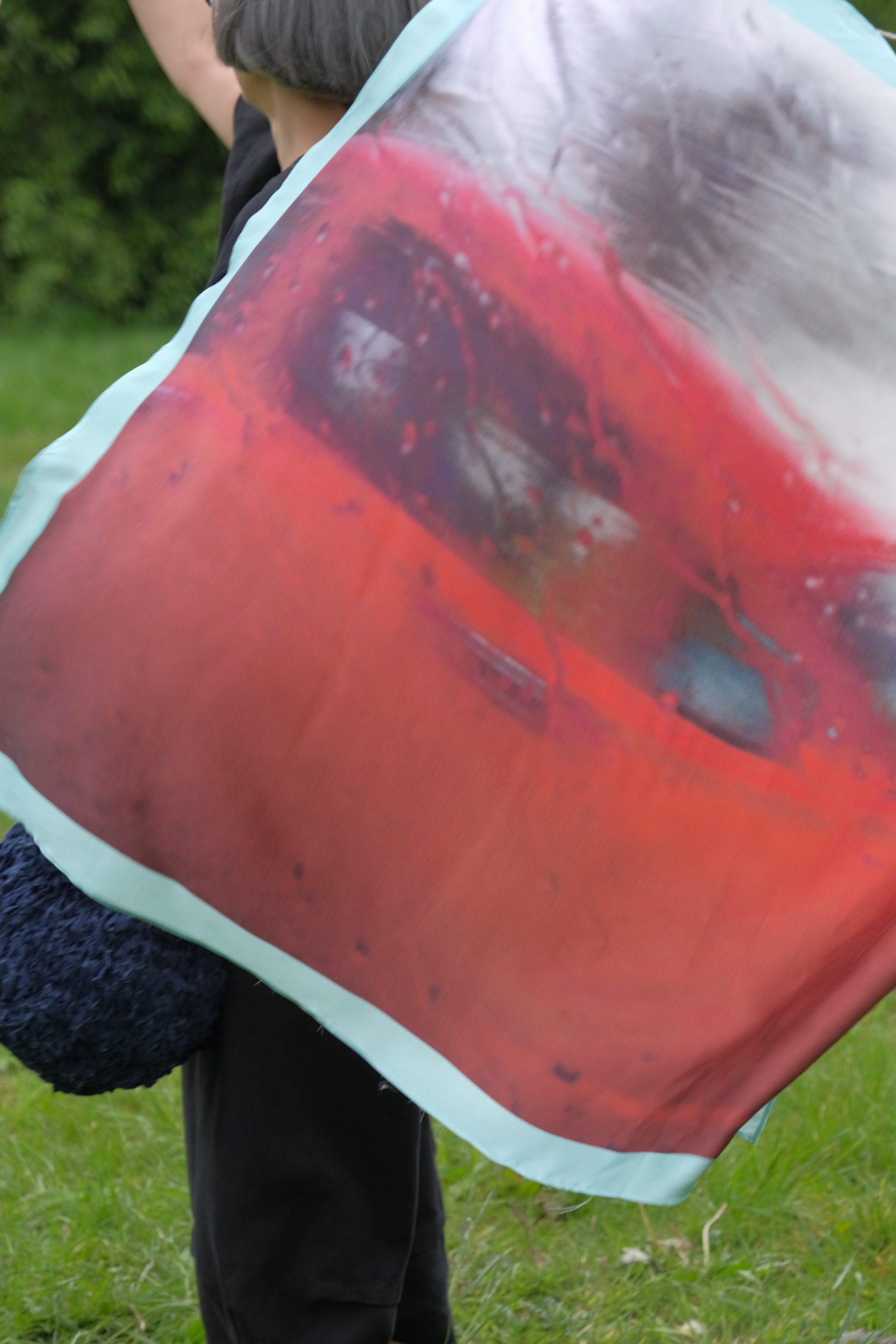 Jen holds up the washing line with the red classic car image silk scarf pegged to it